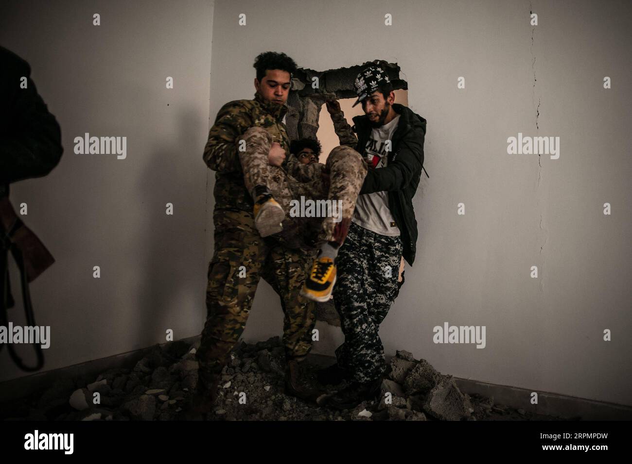200215 -- TRIPOLI, 15. Februar 2020 Xinhua -- Kämpfer der von den Vereinten Nationen unterstützten libyschen Regierungstruppen tragen einen verwundeten Soldaten bei den Zusammenstößen mit LNA-Truppen der libyschen Nationalarmee an der Salah Al-DIN-Frontlinie in Tripoli, Libyen, am 15. Februar 2020. Foto von Amru Salahuddien/Xinhua LIBYA-TRIPOLI-CONFLICT-FRONTLINE PUBLICATIONxNOTxINxCHN Stockfoto