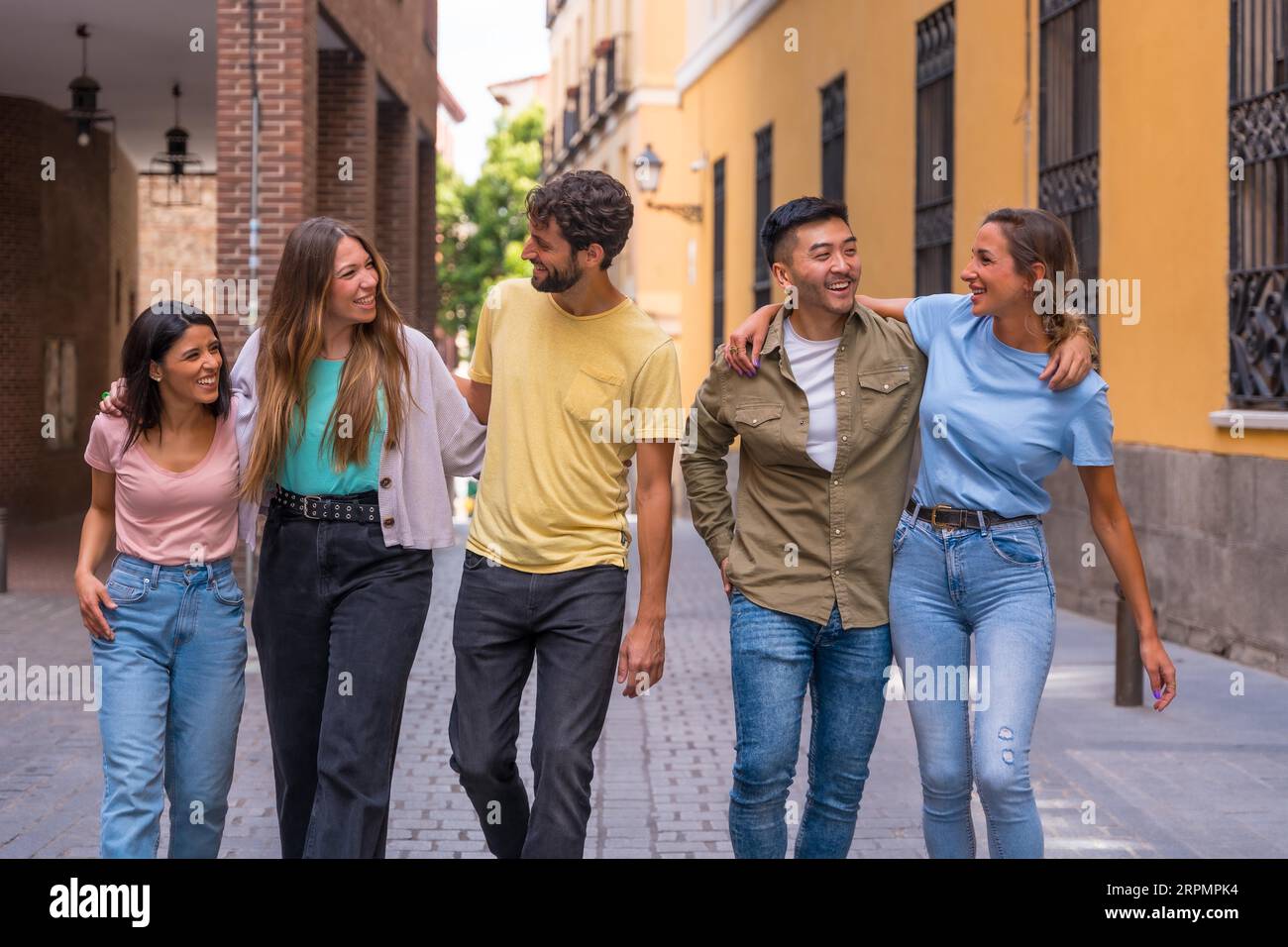Eine Gruppe multirassischer Freunde, die in der Stadt lächeln, ein Freundschaftskonzept mit Jungs und Mädchen, die auf der Straße der Stadt herumhängen Stockfoto