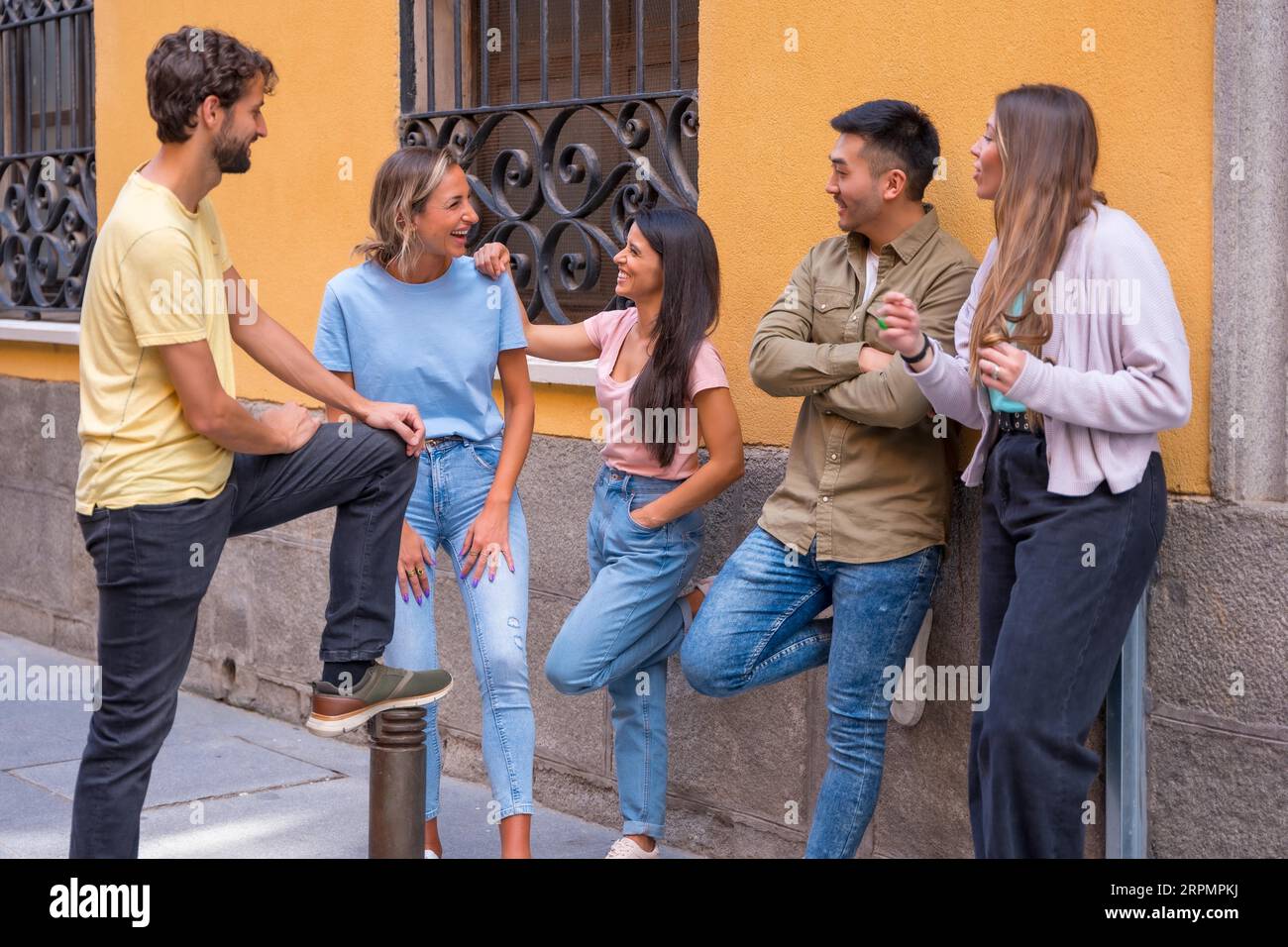 Eine Gruppe von multirassischen Freunden, die sich in der Stadt unterhalten, Freundschaftskonzept mit Jungs und Mädchen Stockfoto