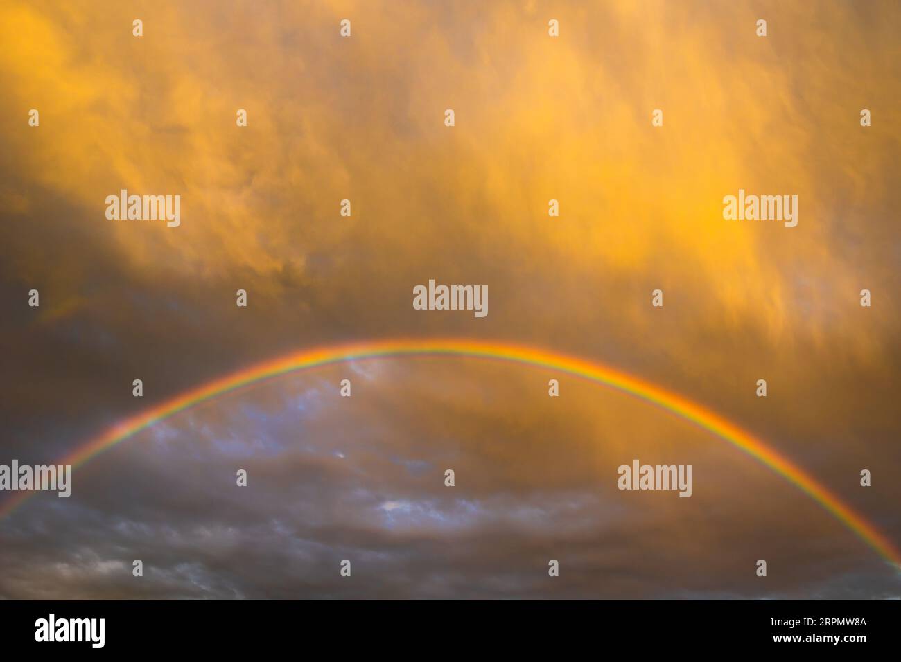 Regenbogen und Wolken bei Sonnenuntergang. Hintergrundfoto der Natur Stockfoto