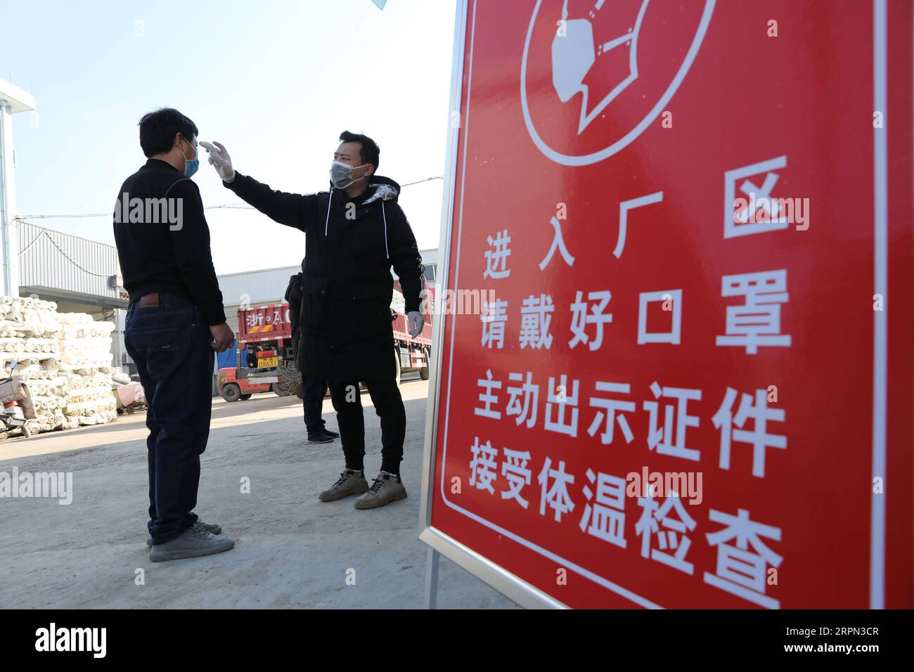 200221 -- HANGZHOU, 21. Februar 2020 -- Ein Arbeiter der Textilfärberei hat seine Körpertemperatur vor dem Betreten der Fabrik in der Gemeinde Tianmushan in einem Bezirk Lin in Hangzhou, ostchinesische Provinz Zhejiang, 20. Februar 2020. Hersteller und Unternehmen haben die Produktion im Rahmen der Seuchenpräventionsmaßnahmen im Rahmen der nationalen Bekämpfung des neuartigen Coronavirus-Ausbruchs wieder aufgenommen. Foto von /Xinhua CHINA-NCP-PRODUCTION RESUMPTION CN HuxJianhuan PUBLICATIONxNOTxINxCHN Stockfoto