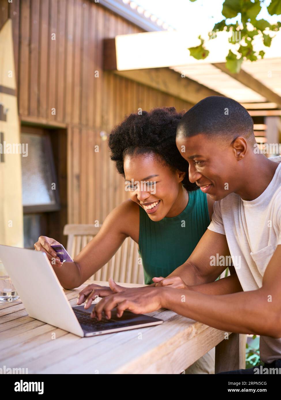 Begeisterte Paare Mit Kreditkarte Mit Laptop Zu Hause, Um Urlaub Zu Buchen Oder Online Einzukaufen Stockfoto