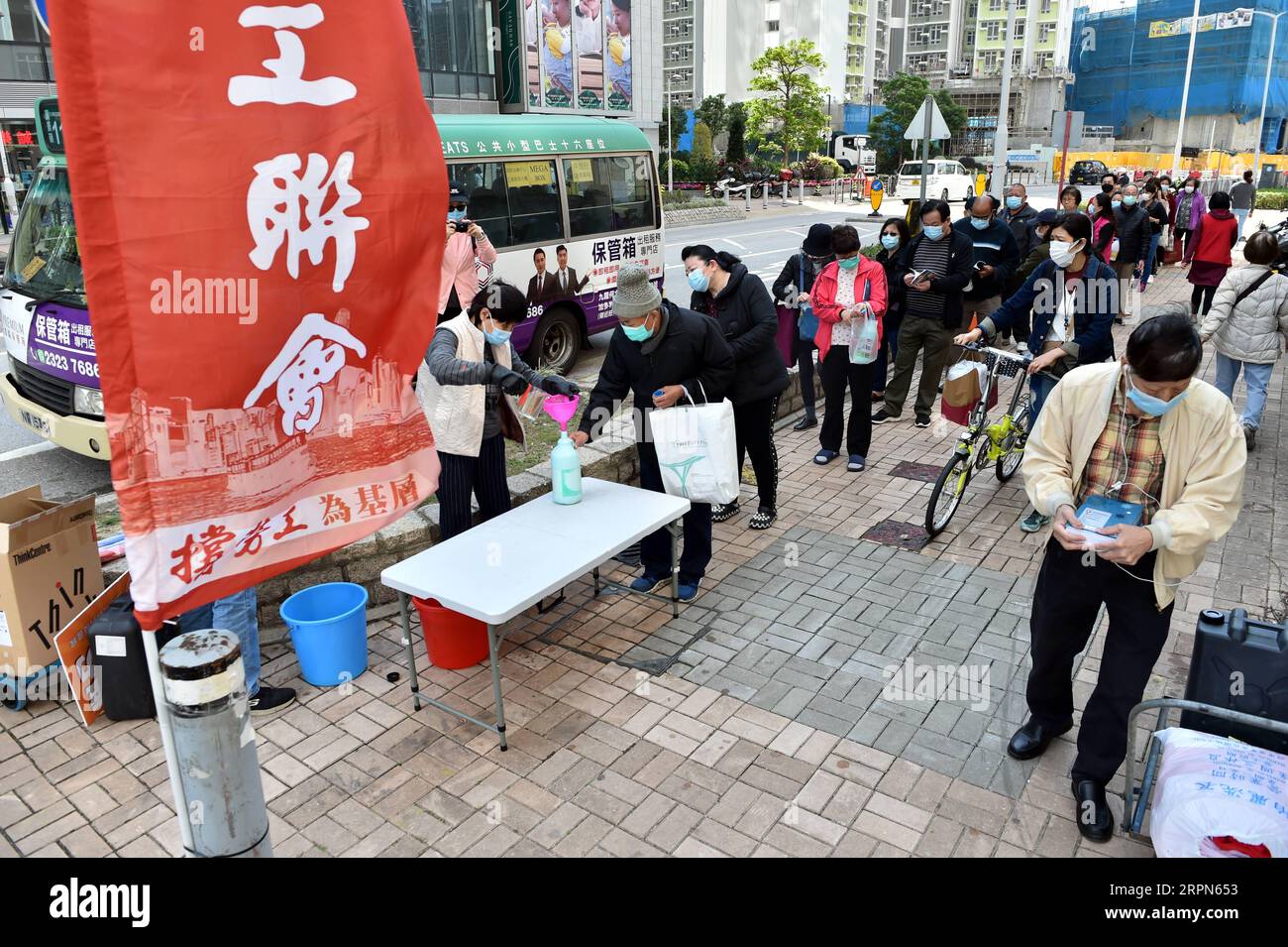 200223 -- HONG KONG, 23. Februar 2020 Xinhua -- Anwohner stellen sich an, um kostenloses Desinfektionsmittel zu erhalten, das von Hong Kong Federation of Trade Unions HKFTU in Tseung Kwan O von Hong Kong, Südchina, 23. Februar 2020 verteilt wird. Xinhua/Lo Ping Fai CHINA-HONG KONG-HKFTU-COVID-19-PREVENTION CN PUBLICATIONxNOTxINxCHN Stockfoto