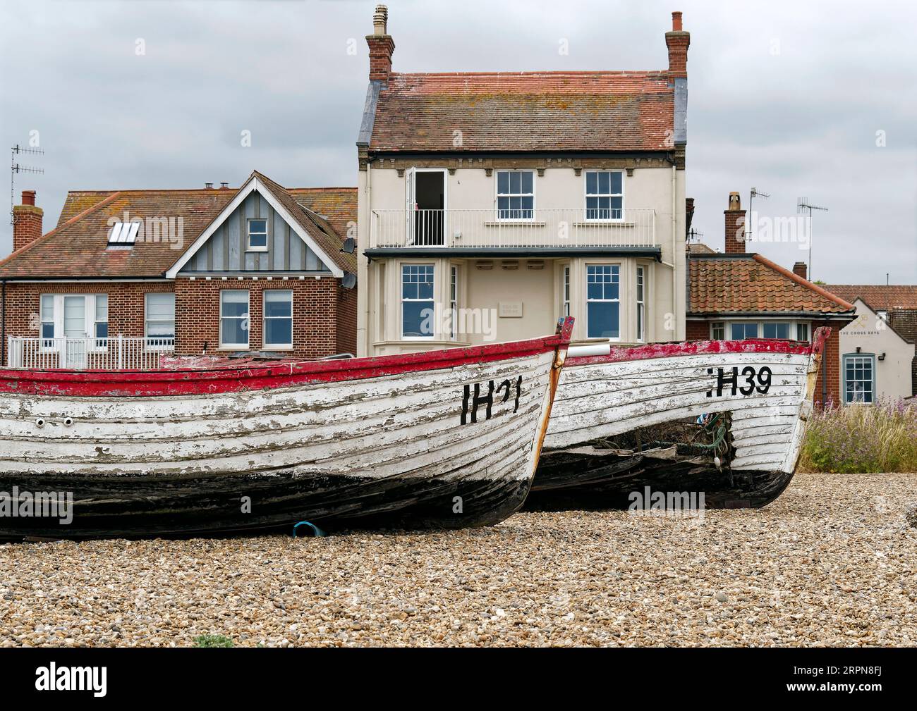 Das verlassene und beschädigte Fishihg-Boot verrottet am Kiesstrand von Aldeburgh, Suffolk, bietet eine malerische, wenn auch traurige Kulisse für diesen Teil der Stadt. Stockfoto