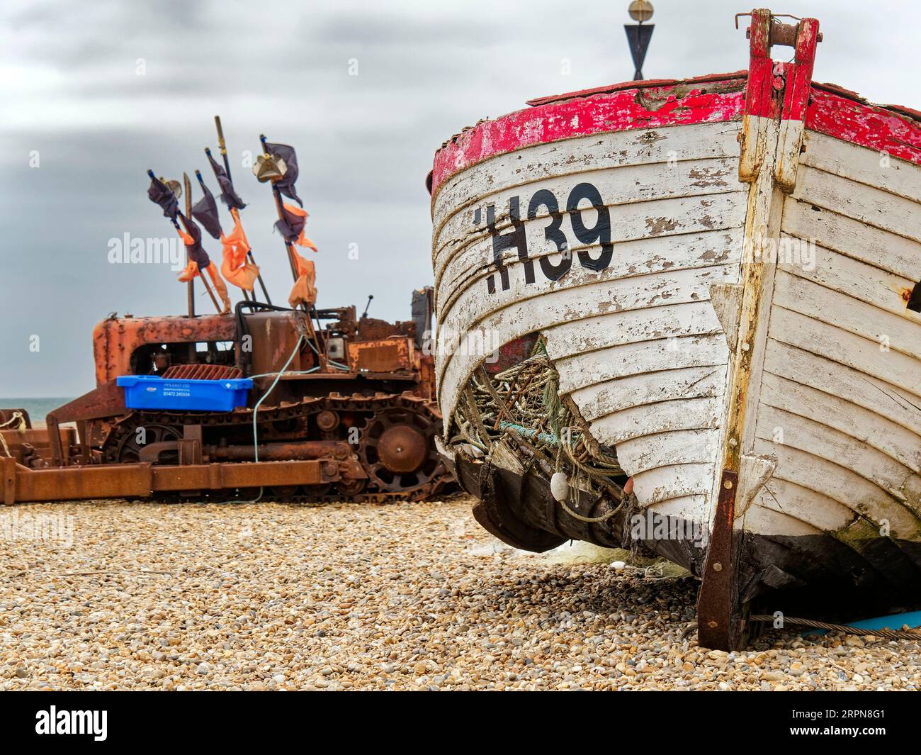 Das verlassene und beschädigte Fishihg-Boot verrottet am Kiesstrand von Aldeburgh, Suffolk, bietet eine malerische, wenn auch traurige Kulisse für diesen Teil der Stadt. Stockfoto