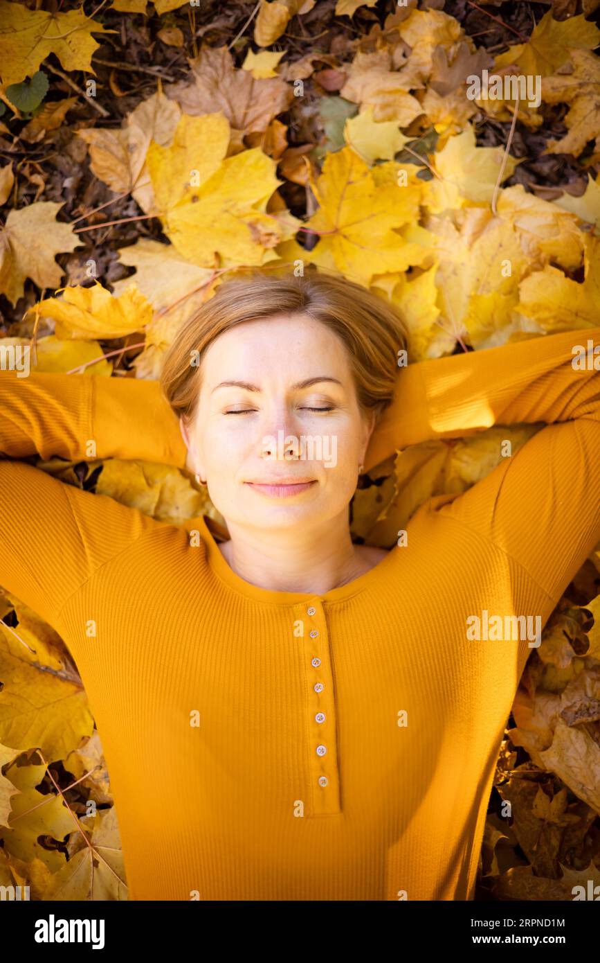 Schöne Frau im Herbstpark. Glück, Harmonie, Selbstfürsorge, Entspannung und Achtsamkeit. Stockfoto