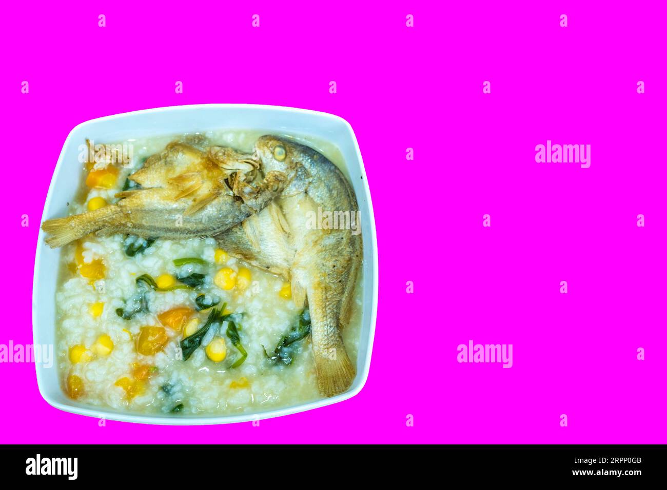 Bubur Manado ist ein traditioneller indonesischer Reisbrei aus Nord-Sulawesi, der oft mit verschiedenen Toppings wie Fisch, Erdnüssen und frittierten Schalotten hergestellt wird. I Stockfoto