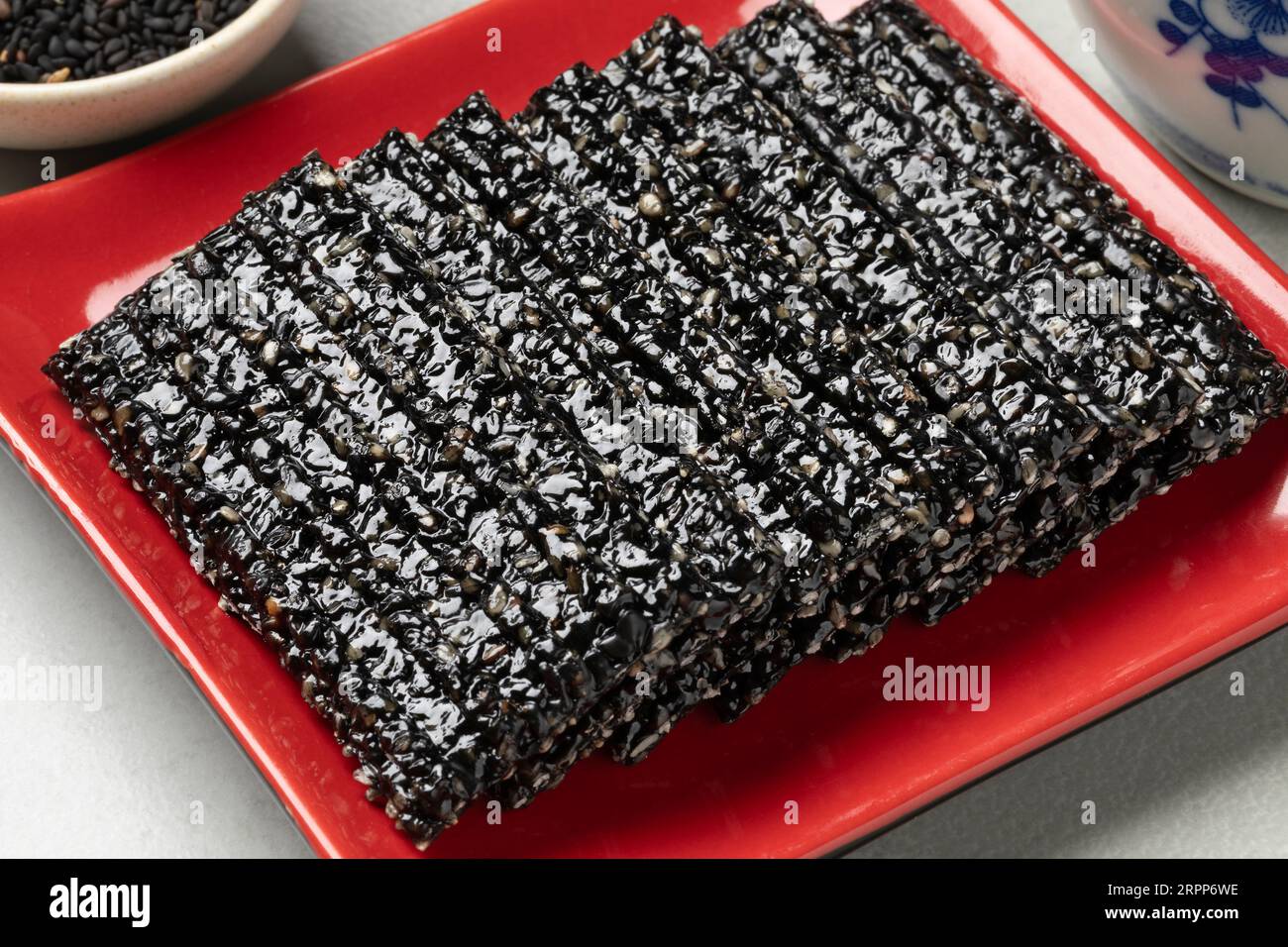 Schwarze Sesamreihe rastet auf einer roten Platte aus Stockfoto