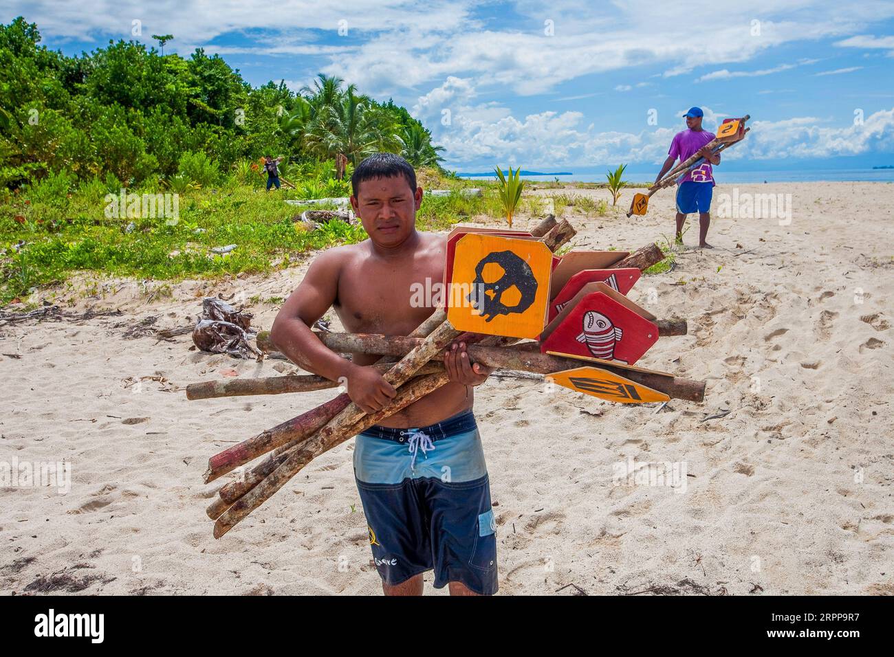 Panama, Archipielago de Bocas del Toro, am Strand von Cayos Zapatilla Männer laden die Bedarfsgegenstände auf ein Boot, das in einem Überlebensfernsehen benutzt wurde Stockfoto