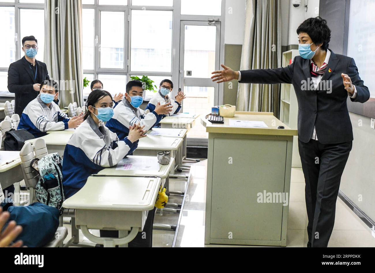 200316 -- ÜRÜMQI, 16. März 2020 -- Ein Lehrer hält ein Klassentreffen an der Oberschule Ürümqi Nr. 1 in Ürümqi, Nordwestchinas autonome Region Xinjiang Uygur, 16. März 2020 ab. Für die Abiturientin in der Autonomen Region Xinjiang Uygur im Nordwesten Chinas unterscheidet sich der Unterricht am Montag von dem, den sie in den letzten zwei Wochen absolviert hat: Sie hat sich endlich von online auf offline verlagert. Montag ist der erste Tag der Offline-Schule des neuen Semesters für Schüler in ihren letzten Jahren an höheren und höheren Schulen und Berufsschulen in Xinjiang, einer der Stockfoto