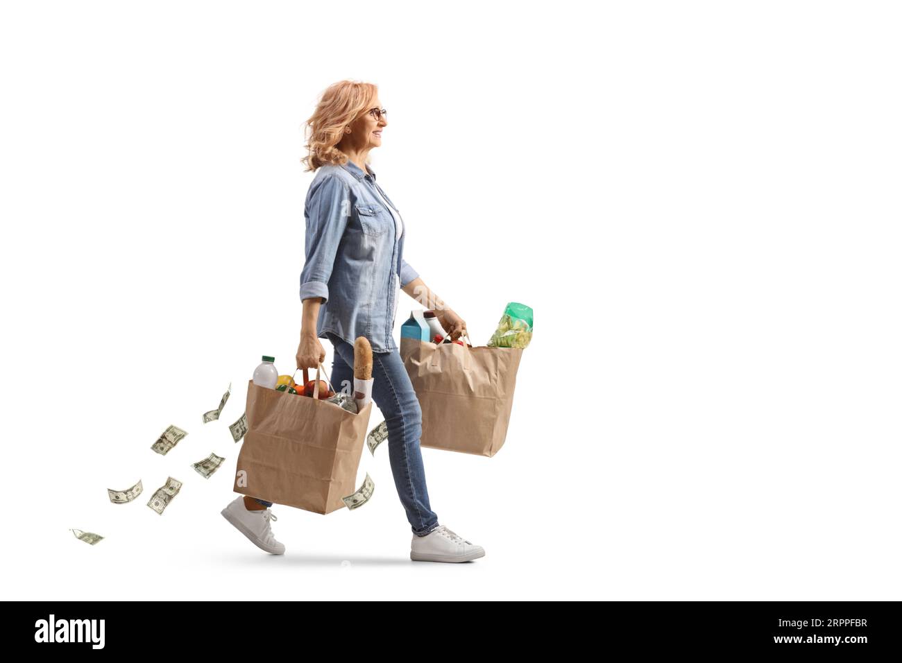 Profilaufnahme in voller Länge einer Frau, die mit Lebensmitteltüten und Geld dahinterfliegt, isoliert auf weißem Hintergrund Stockfoto