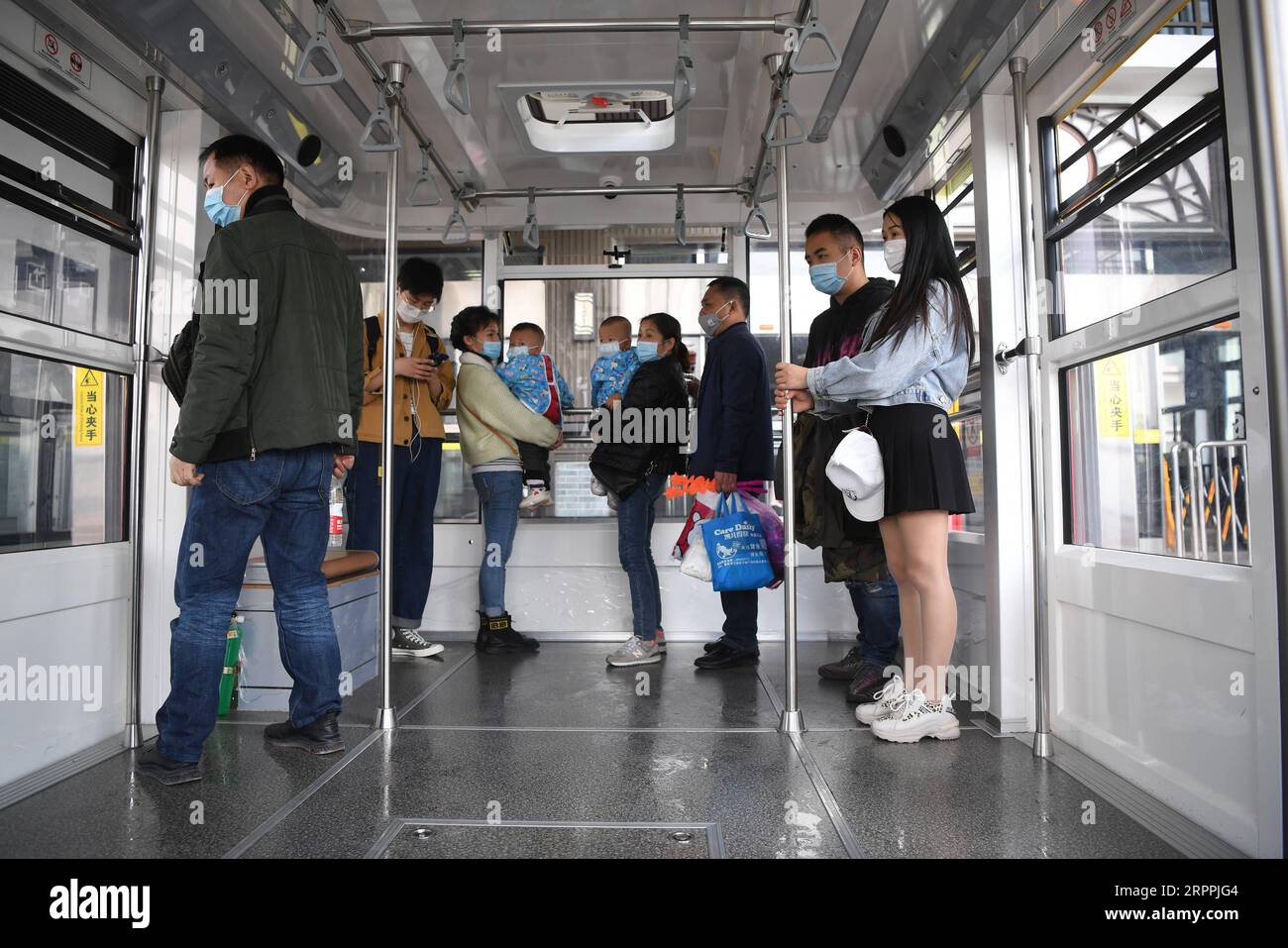 200318 -- CHONGQING, 18. März 2020 -- Passagiere gehen an Bord einer Seilbahn im südwestchinesischen Chongqing, 18. März 2020. Die Seilbahn über den Yangtze-Fluss wurde hier am Mittwoch wieder eröffnet. CHINA-CHONGQING-COVID-19-CABLEWAY-REOPEN CN TANGXYI PUBLICATIONXNOTXINXCHN Stockfoto