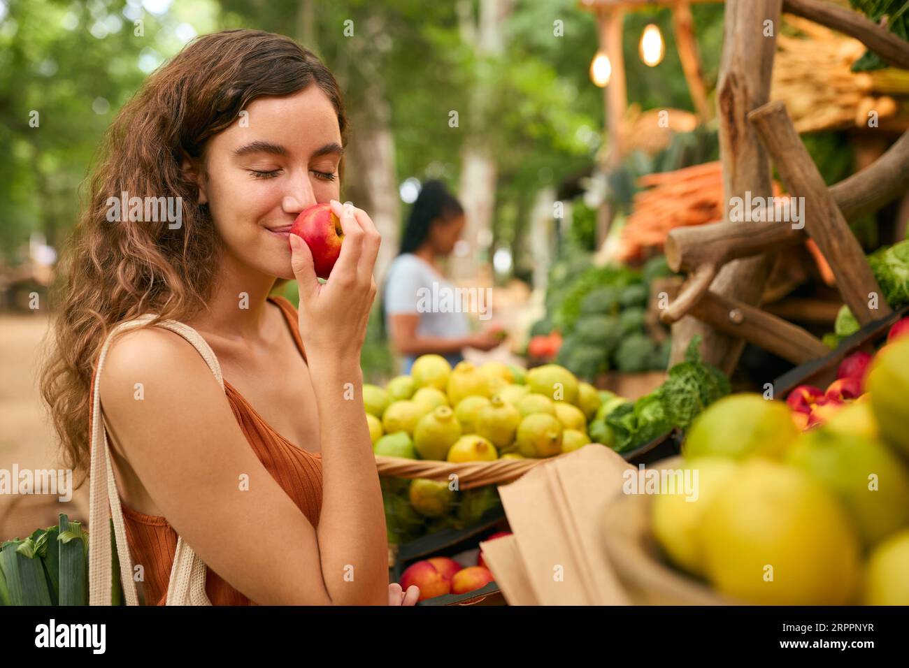Weibliche Kundin Am Marktstand, Die Frisches Obst Und Gemüse Riecht Stockfoto
