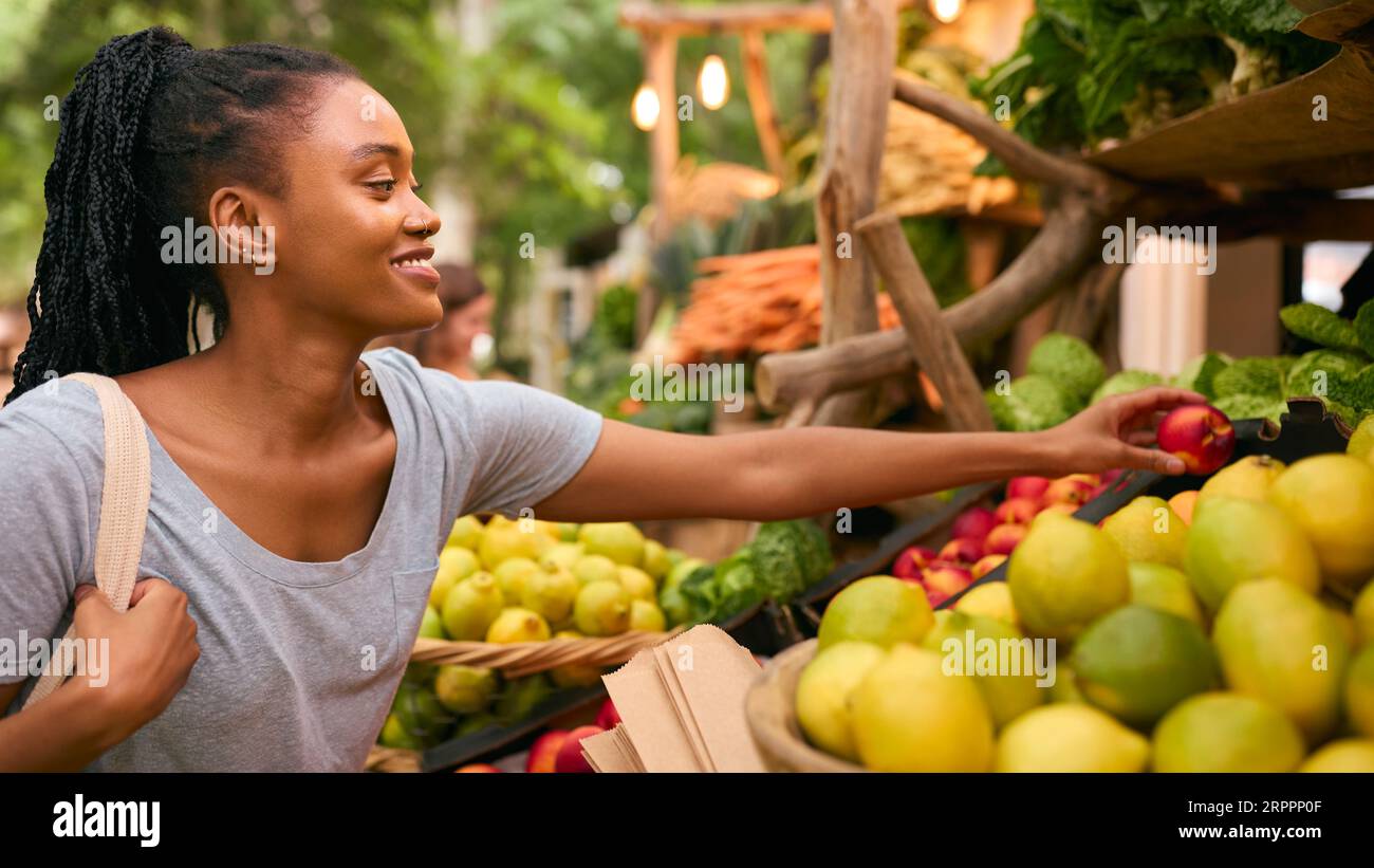 Weibliche Kundin Am Verkaufsstand, Die Frisches Obst Und Gemüse Wählt Stockfoto