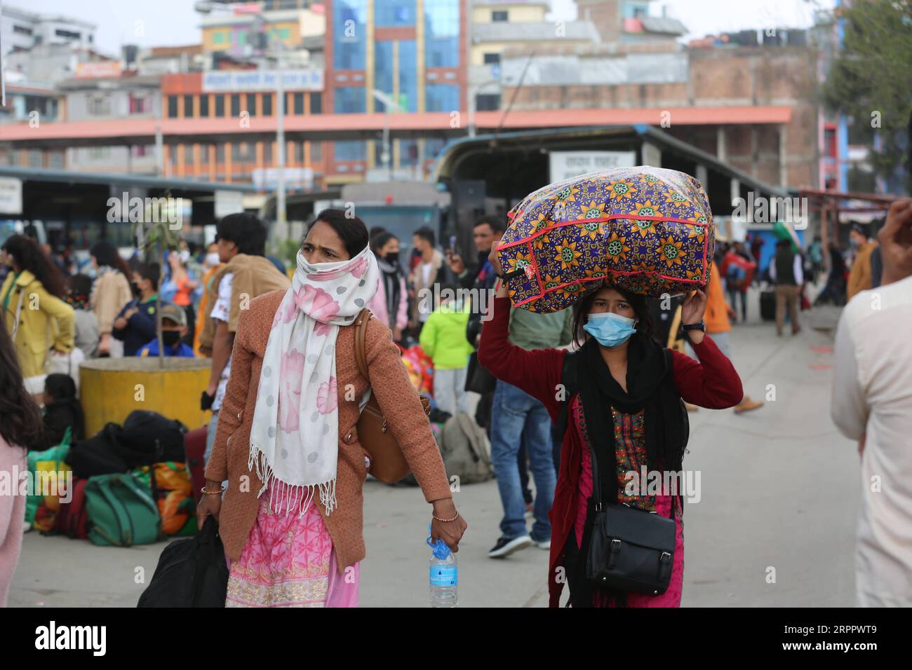 200322 -- KATHMANDU, 22. März 2020 -- Passagiere gehen an einer Bushaltestelle in Kathmandu, Nepal, 22. März 2020. Der nepalesische Premierminister KP Sharma Oli kündigte am 20. März eine Reihe von Verbotsmaßnahmen an, darunter die Aussetzung des Fernverkehrs aufgrund des COVID-19-Ausbruchs. In einer Rede vor der Nation am Freitagabend kündigte der Premierminister an, dass alle Fernverkehrsdienste ab dem 23. März eingestellt werden. Zhou Shengping NEPAL-KATHMANDU-LANGSTRECKENTRANSPORT zhoushengping PUBLICATIONxNOTxINxCHN Stockfoto