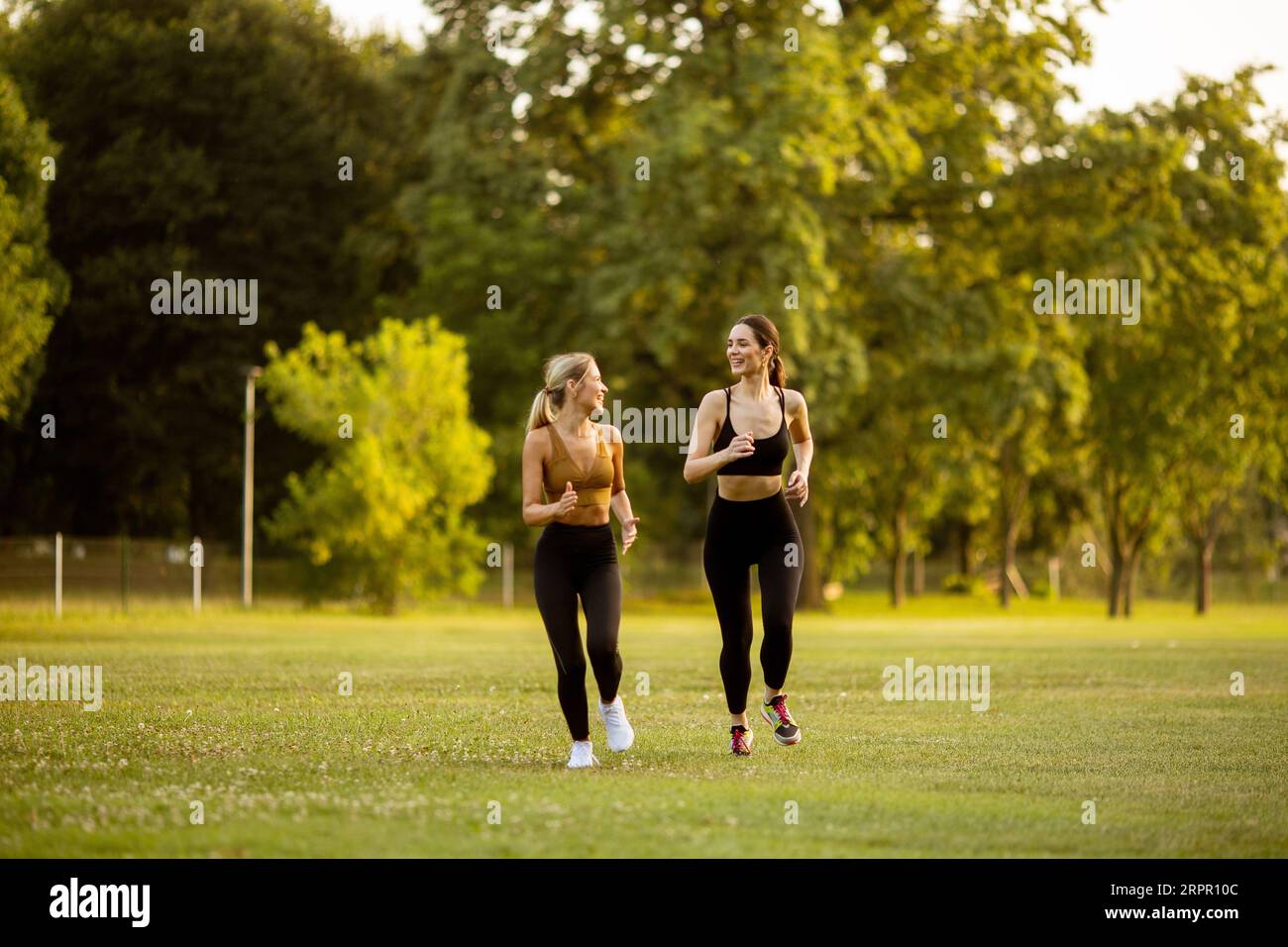 Zwei hübsche junge Frauen Rennen im Park Stockfoto
