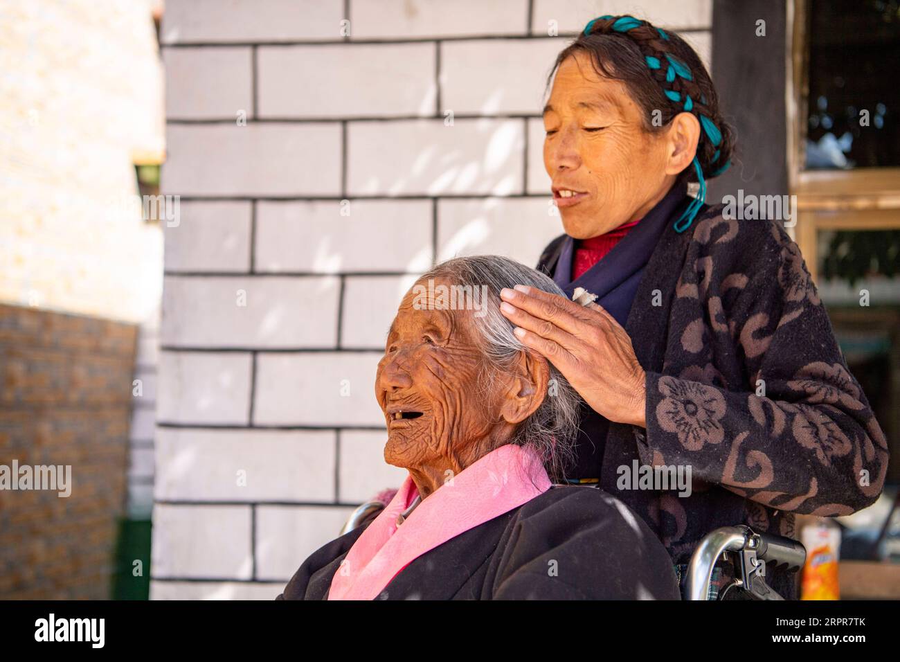 200328 -- LHASA, 28. März 2020 -- Tsering Dzongpa kämmt Haare für ihre Mutter Sonam Drolma Front im Reguo Village im Gyaca County in Shannan, südwestchinesische Autonome Region Tibet, 24. März 2020. Am Samstag findet der Tag der Emanzipation der Sklaven statt. Vor einundsechzig Jahren wurden mehr als eine Million Menschen, das sind 90 Prozent der damaligen Bevölkerung der Region, von der feudalen Leibeigenschaft befreit. Sonam Drolma ist eine 109-jährige Dorfbewohnerin im Dorf Reguo in Shannan. Seit ihrer Geburt durchlebte sie ein halbes Jahrhundert voller Wendungen und Leiden als Leibeigene. Sonam Drolma b Stockfoto