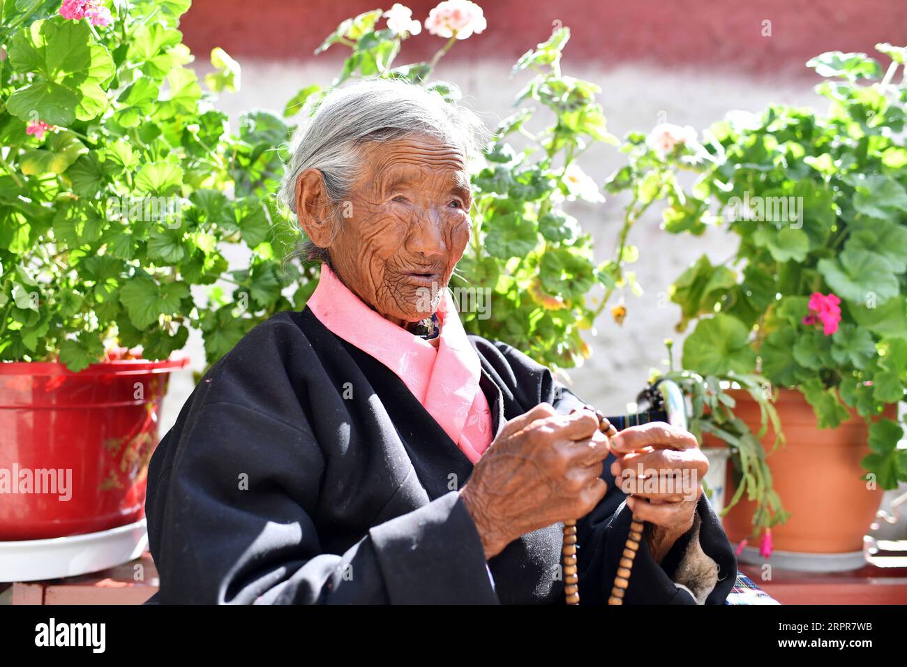 200328 -- LHASA, 28. März 2020 -- Sonam Drolma sitzt im Innenhof zu Hause im Dorf Reguo im Gyaca County in Shannan, Südwestchinas Autonome Region Tibet, 24. März 2020. Am Samstag findet der Tag der Emanzipation der Sklaven statt. Vor einundsechzig Jahren wurden mehr als eine Million Menschen, das sind 90 Prozent der damaligen Bevölkerung der Region, von der feudalen Leibeigenschaft befreit. Sonam Drolma ist eine 109-jährige Dorfbewohnerin im Dorf Reguo in Shannan. Seit ihrer Geburt durchlebte sie ein halbes Jahrhundert voller Wendungen und Leiden als Leibeigene. Als Nachfahre von Leibeigenen begann Sonam Drolma, für s zu arbeiten Stockfoto