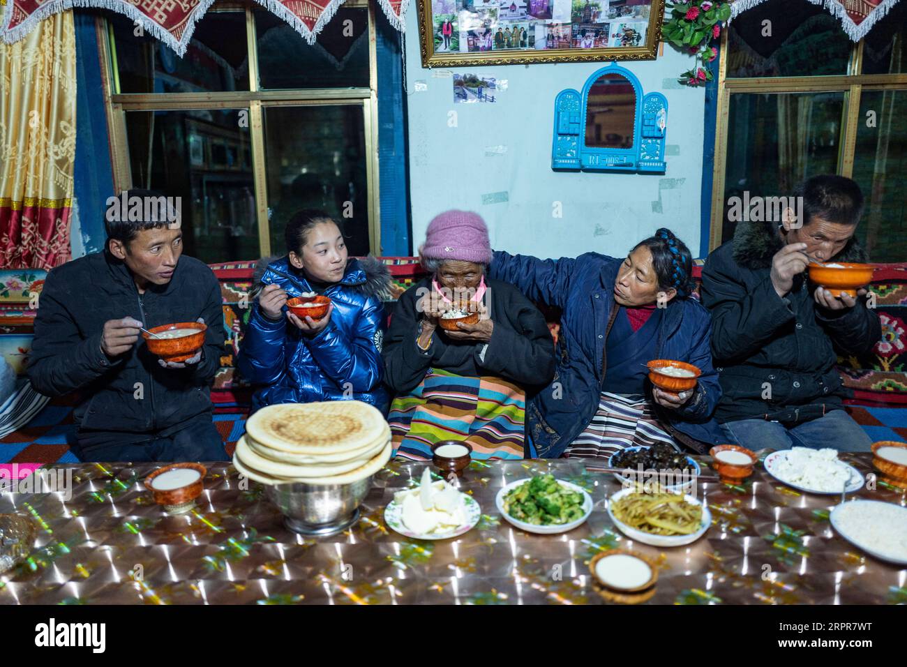 200328 -- LHASA, 28. März 2020 -- Sonam Drolma C und ihre Familie essen im Reguo Village im Gyaca County in Shannan, Südwestchinas Autonome Region Tibet, 24. März 2020. Am Samstag findet der Tag der Emanzipation der Sklaven statt. Vor einundsechzig Jahren wurden mehr als eine Million Menschen, das sind 90 Prozent der damaligen Bevölkerung der Region, von der feudalen Leibeigenschaft befreit. Sonam Drolma ist eine 109-jährige Dorfbewohnerin im Dorf Reguo in Shannan. Seit ihrer Geburt durchlebte sie ein halbes Jahrhundert voller Wendungen und Leiden als Leibeigene. Als Nachfahre von Sklaven begann Sonam Drolma, für se zu arbeiten Stockfoto