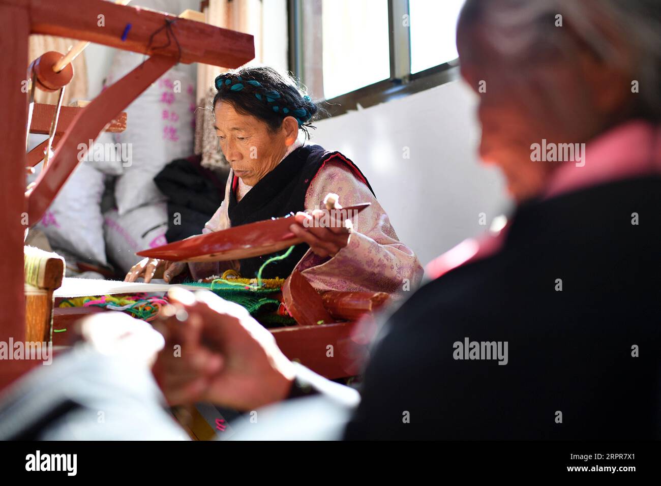 200328 -- LHASA, 28. März 2020 -- Tsering Dzongpa webt Wolle im Dorf Reguo im Gyaca County in Shannan, im Südwesten Chinas Autonome Region Tibet, 24. März 2020. Am Samstag findet der Tag der Emanzipation der Sklaven statt. Vor einundsechzig Jahren wurden mehr als eine Million Menschen, das sind 90 Prozent der damaligen Bevölkerung der Region, von der feudalen Leibeigenschaft befreit. Sonam Drolma ist eine 109-jährige Dorfbewohnerin im Dorf Reguo in Shannan. Seit ihrer Geburt durchlebte sie ein halbes Jahrhundert voller Wendungen und Leiden als Leibeigene. Als Nachfahre von Leibeigenen begann Sonam Drolma, für Leibeigenbesitzer bei zu arbeiten Stockfoto