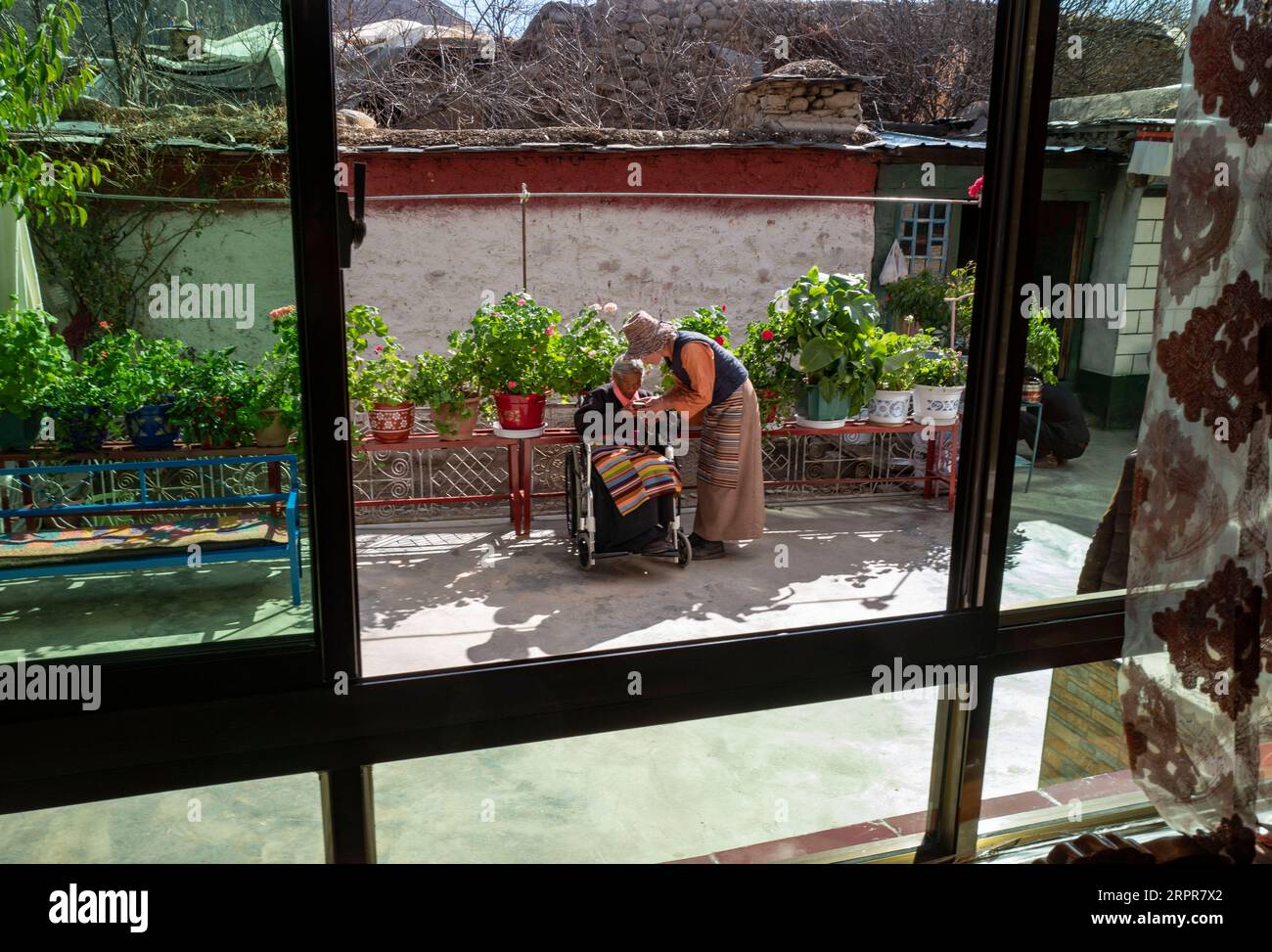 200328 -- LHASA, 28. März 2020 -- Sonam Drolmas Schwiegertochter serviert ihr Buttertee im Reguo Village im Gyaca County in Shannan, im Südwesten Chinas Autonome Region Tibet, 24. März 2020. Am Samstag findet der Tag der Emanzipation der Sklaven statt. Vor einundsechzig Jahren wurden mehr als eine Million Menschen, das sind 90 Prozent der damaligen Bevölkerung der Region, von der feudalen Leibeigenschaft befreit. Sonam Drolma ist eine 109-jährige Dorfbewohnerin im Dorf Reguo in Shannan. Seit ihrer Geburt durchlebte sie ein halbes Jahrhundert voller Wendungen und Leiden als Leibeigene. Als Nachfahre von Leibeigenen Sonam Drolma Stockfoto