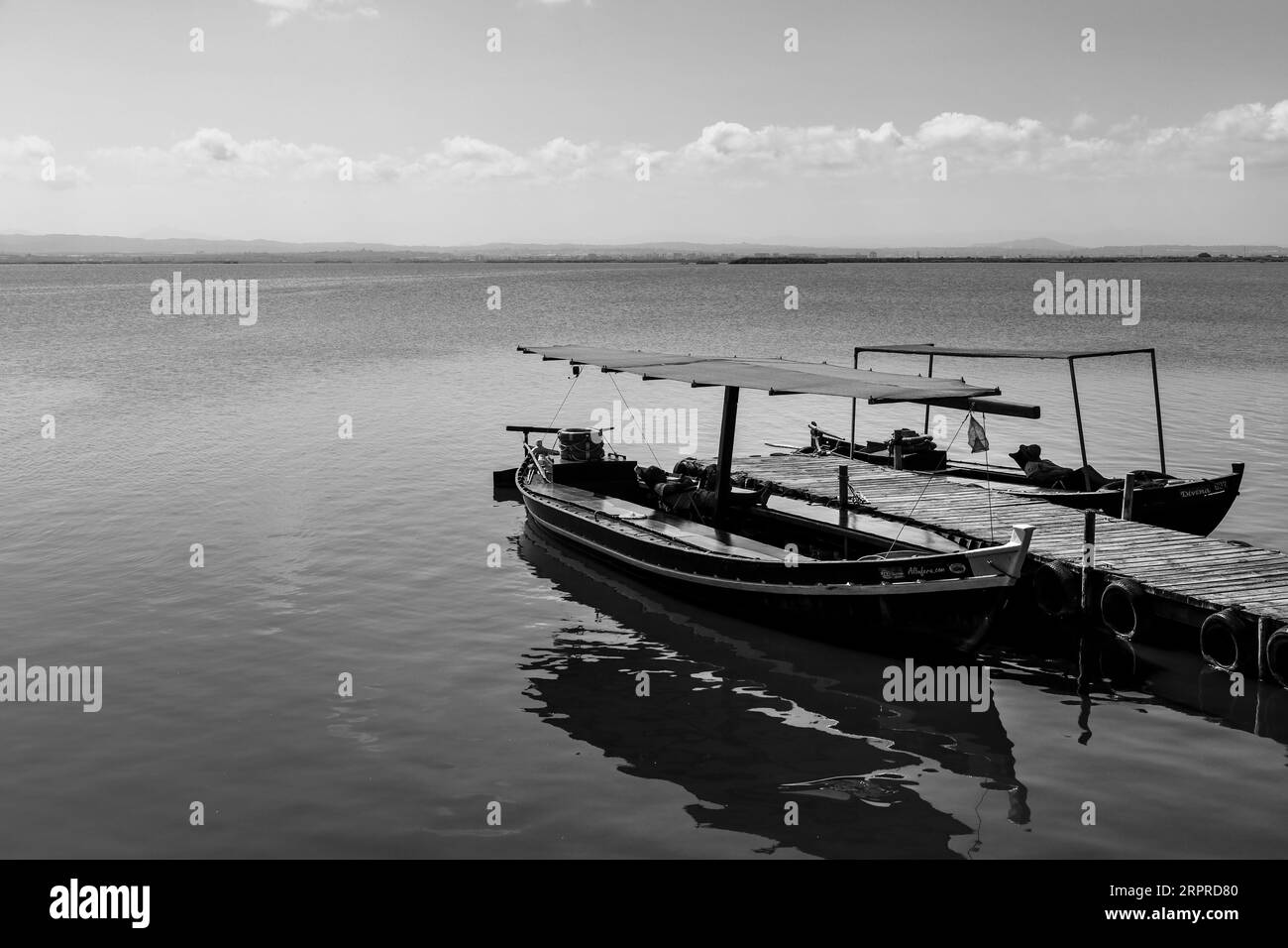 Valencia, Spanien - 15. August 2023: Traditionelle Fischerboote, die an der Anlegestelle in der Lagune La Albufera in Valencia, Spanien, vor Anker liegen Stockfoto