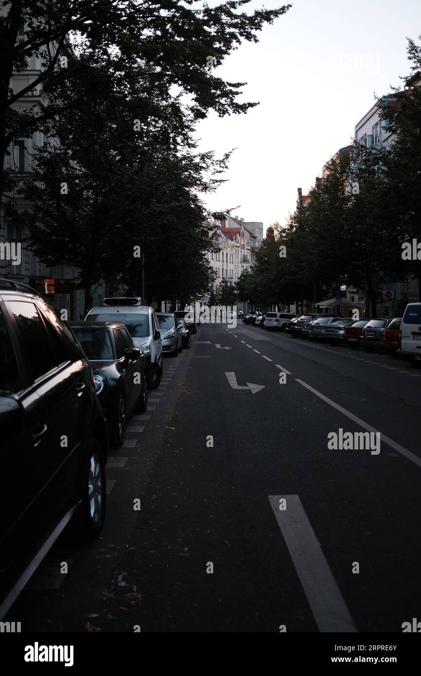 Eine Reihe von Autos parkte auf einer Straße vor mehreren Gebäuden Stockfoto