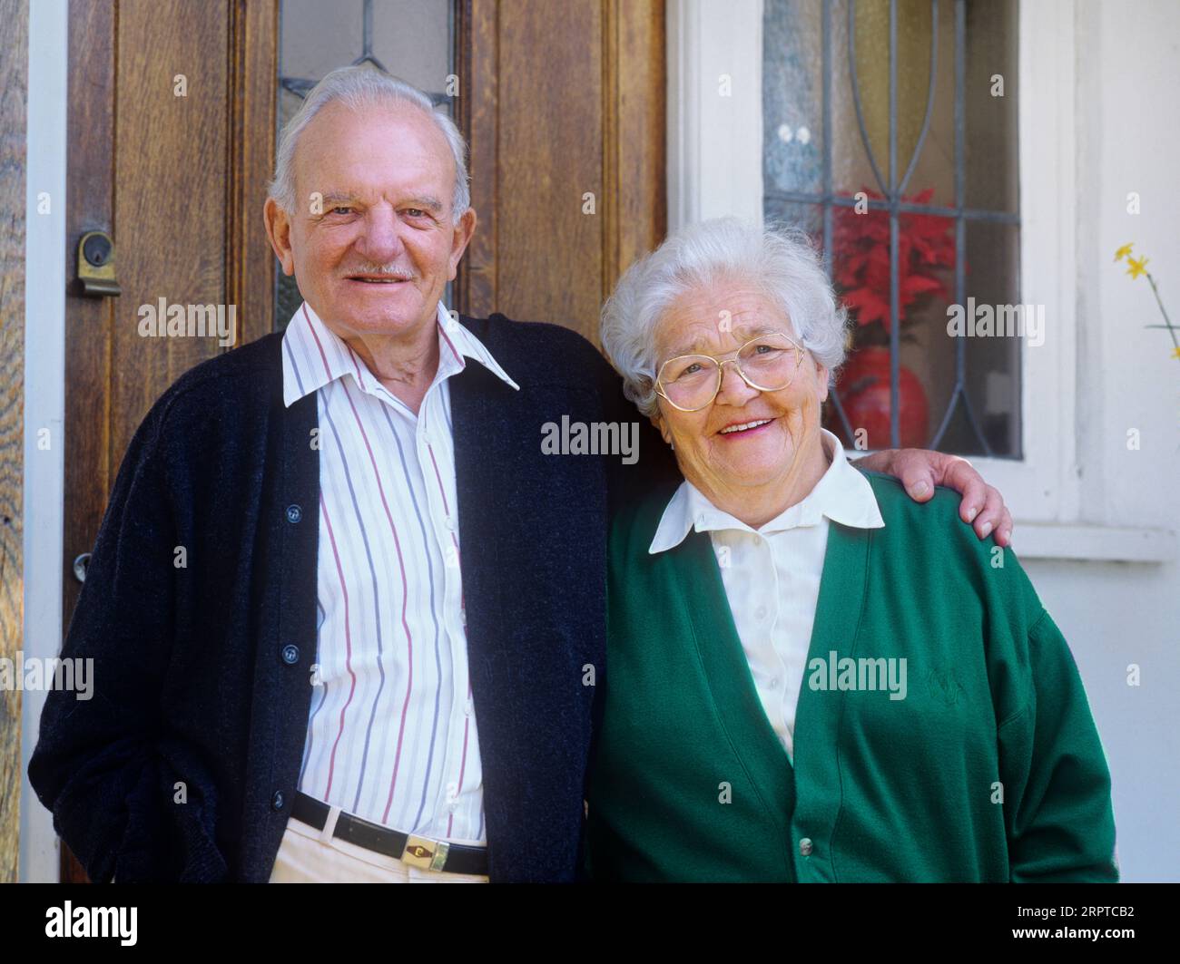 Ältere Ehepaare ältere Hausbesitzer ältere Rentner glückliches entspanntes Paar 80-86 Jahre Hausbesitzer Hypothekenfrei, vor der Eingangstür zu ihrem komfortablen Haus aus den 1930er Jahren Stockfoto
