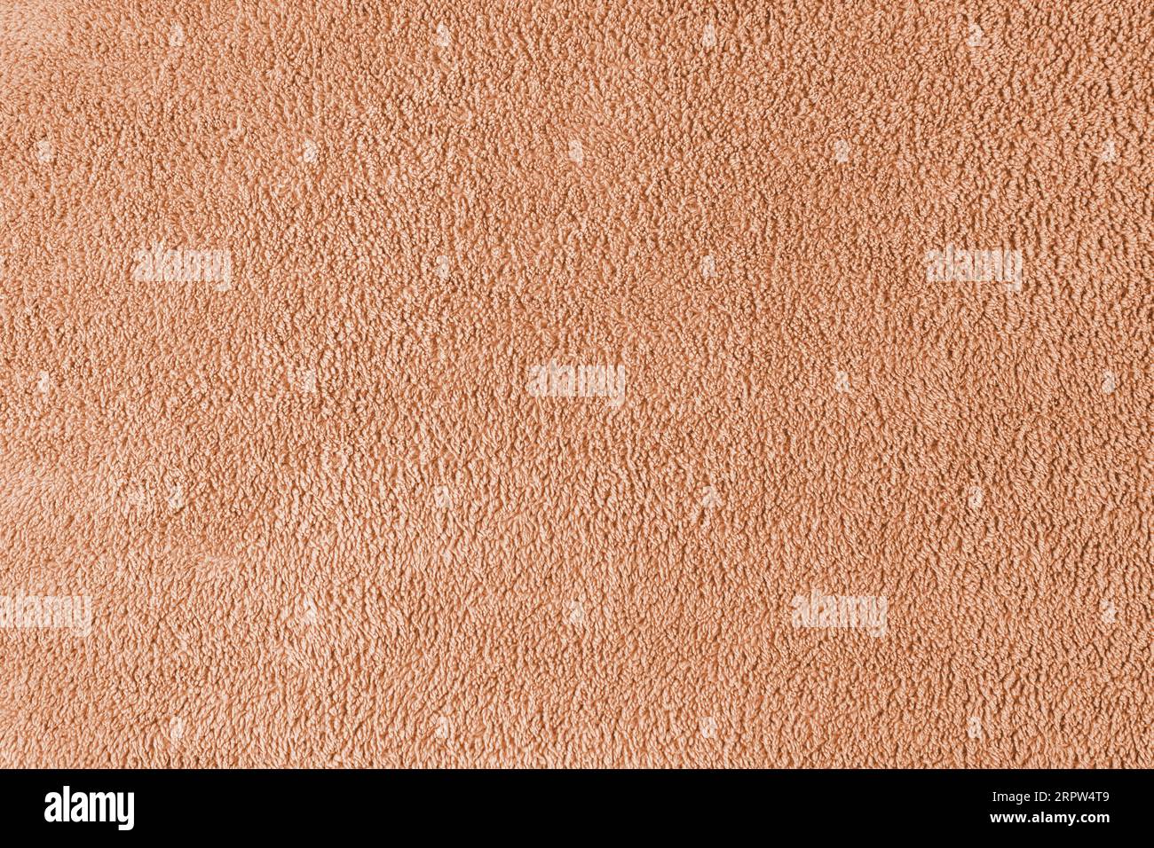 Frottee, orangefarbener Handtuchhintergrund. Weiches, flauschiges Textil-Bad- oder Strandhandtuchmaterial. Draufsicht, Nahaufnahme. Stockfoto