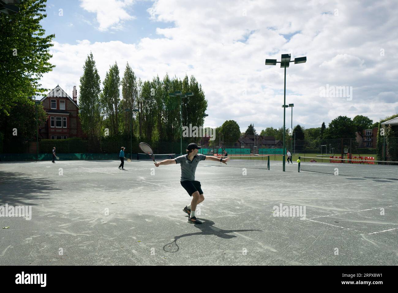 200514 -- MANCHESTER, 14. Mai 2020 -- Tennistrainer Jonny Kinsella C spielt einen Schuss auf den Northern Lawn Tennis Club, da Mitglieder der Öffentlichkeit am 13. Mai 2020 in Manchester, Großbritannien, wieder bestimmte Sportarten unter sozialen Distanzierungsbedingungen ausüben dürfen. Nach Angaben der britischen Regierung können die Menschen von Mittwoch an jeden Tag so oft draußen trainieren, wie sie es wünschen, anstatt nur einmal am Tag. Foto von /Xinhua SPBRITAIN-MANCHESTER-COVID-19-GOLF-TENNIS-RESUME JonxSuper PUBLICATIONxNOTxINxCHN Stockfoto