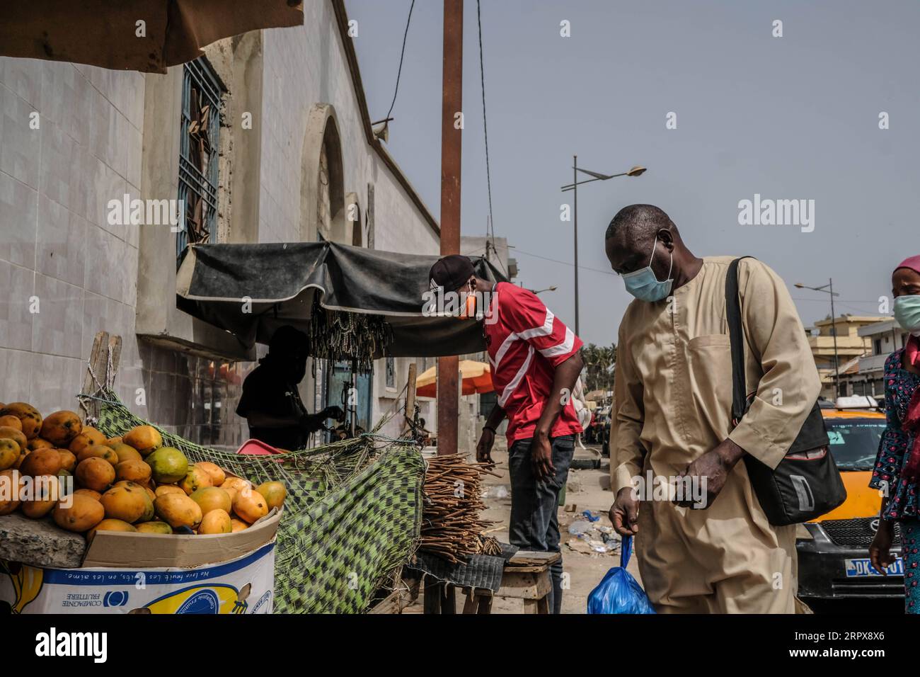 200514 -- DAKAR, 14. Mai 2020 Xinhua -- Ein Mann, Der eine Gesichtsmaske trägt, kauft Früchte von einem Straßenhändler in Dakar, Senegal, 12. Mai 2020. Senegal meldete am Mittwoch 110 neue bestätigte COVID-19-Fälle, womit die Gesamtzahl im Land auf 2.105 gestiegen ist. Foto von Eddy Peters/Xinhua SENEGAL-DAKAR-COVID-19-CASES PUBLICATIONxNOTxINxCHN Stockfoto