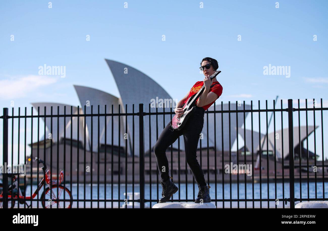 200520 -- SYDNEY, 20. Mai 2020 -- Eine junge Frau spielt Gitarre in der Nähe des Sydney Opera House in Sydney, Australien, 20. Mai 2020. Australier im Bundesstaat New South Wales, NSW, werden bald einen regionalen Urlaub genießen können, wobei die COVID-19-Beschränkungen ab dem nächsten Monat aufgehoben werden und Tausenden mit Existenzmöglichkeiten in der Tourismusbranche Hoffnung bieten werden. Da in den letzten Tagen nur eine Handvoll neuer COVID-19-Fälle aufgetreten sind, hielten es die Staats- und Regierungschefs der NSW am Mittwoch für angebracht, eine Lockerung der Gesetze zur sozialen Distanzierung anzukündigen, die ab dem 1. Juni in Kraft treten. AUSTRALIEN-SYDNEY-COVID-19-RESTRIKTIONEN-LOCKERUNG BaixXuefei PUBLICATIONxNOTxINxCHN Stockfoto