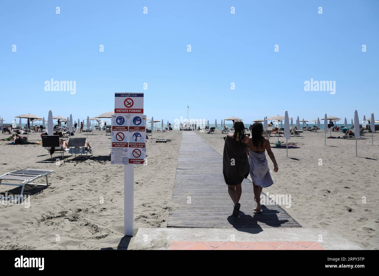 200613 -- LATIUM, 13. Juni 2020 -- Menschen gehen an einer Plakatwand von Epidemie-Präventionsvorschriften am Strand in Fregene, Latium, Italien, 12. Juni 2020. Die COVID-19-Fälle Italiens sanken erstmals seit dem 18. März auf 28.997, unter 30.000, nachdem die Zahl am Freitag nach den neuesten offiziellen Daten um 1.640 zurückgegangen war. ITALIEN-LAZIO-COVID-19-FÄLLE-TROPFEN ChengxTingting PUBLICATIONxNOTxINxCHN Stockfoto