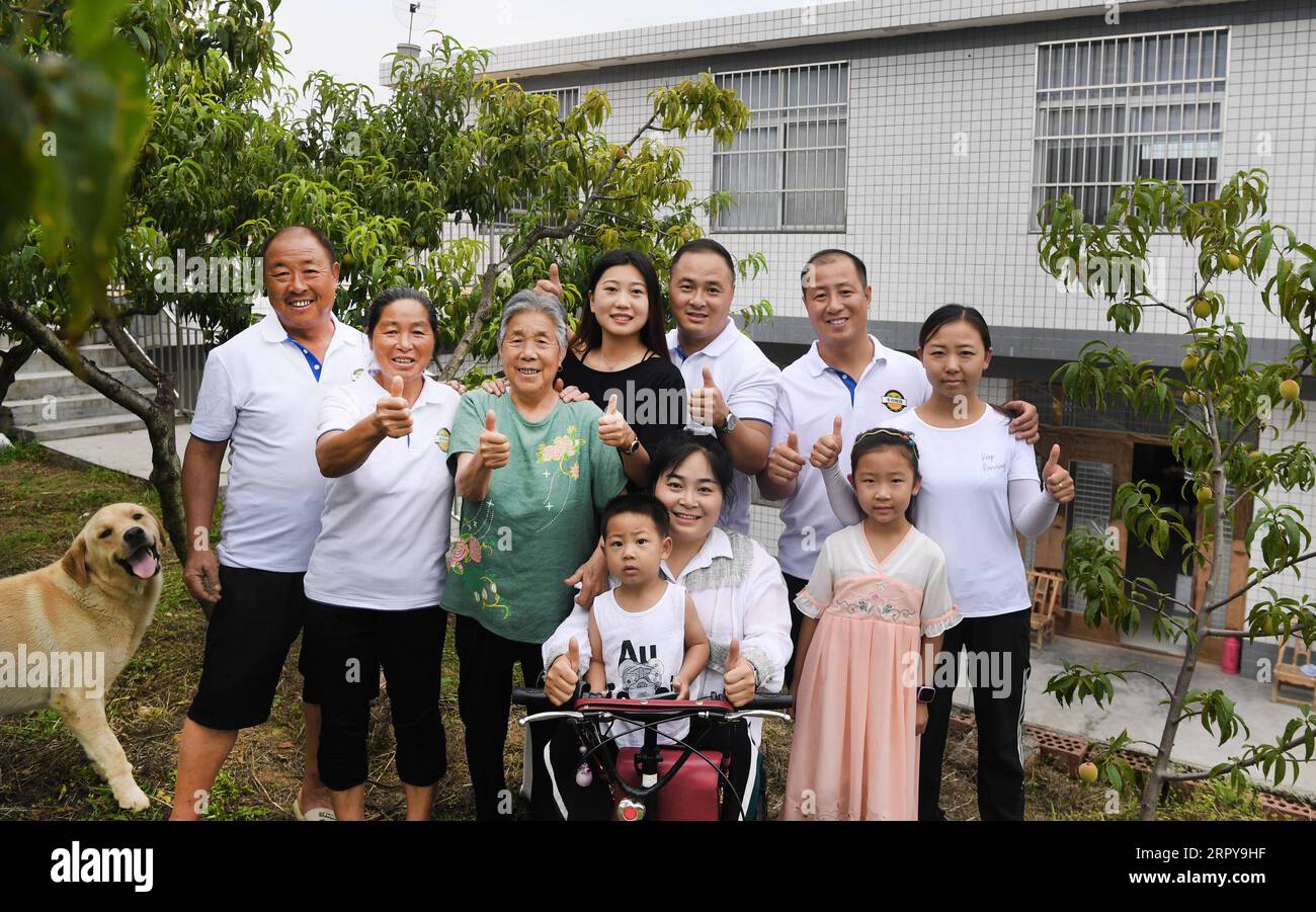 200621 -- ANKANG, 21. Juni 2020 -- Li Zengyi 1st L und seine Familie posieren für ein Foto im Dorf Wenhua im Bezirk Hanbin der Stadt Ankang, Provinz Shaanxi im Nordwesten Chinas, 19. Juni 2020. Um die Armut abzuschütteln, verlegte Li Zengyi, ein Dorfbewohner im Dorf Wenhua der Stadt Ankang, 1997 seine Familie, einschließlich seiner siebenjährigen behinderten Tochter, in ein provisorisches Haus auf einem Berg, um Pfirsiche anzubauen. Li Wei, der ältere Sohn von Li Zengyi, ging nach dem Abschluss der Mittelschule in die südchinesische Provinz Guangdong, um die Familie zu unterstützen. Li Peng, der jüngere Sohn, setzte sein Studium fort Stockfoto