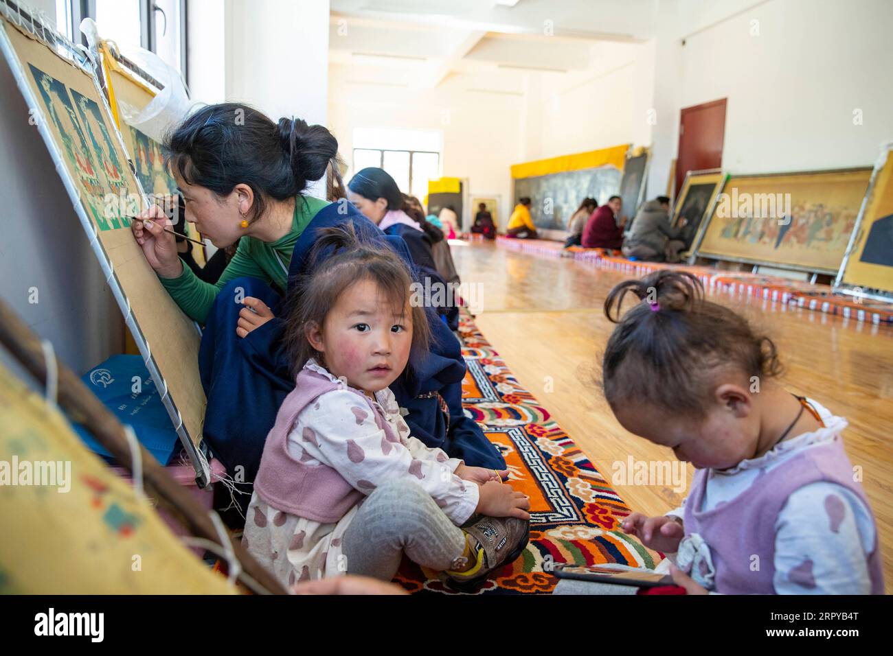 200623 -- MAOXIAN, 23. Juni 2020 -- Eine Dorfbewohnerin in Begleitung ihrer Zwillingstöchter erstellt ein Tangka-Gemälde in einer Werkstatt, in der Dorfbewohner im Rangtang County von Aba Tibetan und der autonomen Präfektur Qiang, Provinz Sichuan im Südwesten Chinas, am 13. Juni 2020 kostenlos traditionelles Handwerk erlernen können. Die autonome Präfektur Aba Tibetan und Qiang liegt im Nordwesten der Provinz Sichuan und hat eine Vielzahl von ethnischen Minderheiten, darunter Tibeter, Qiang und Hui Um die ethnische Kultur besser zu vererben, haben die örtlichen Schulen in den letzten Jahren traditionellere c eingeführt Stockfoto