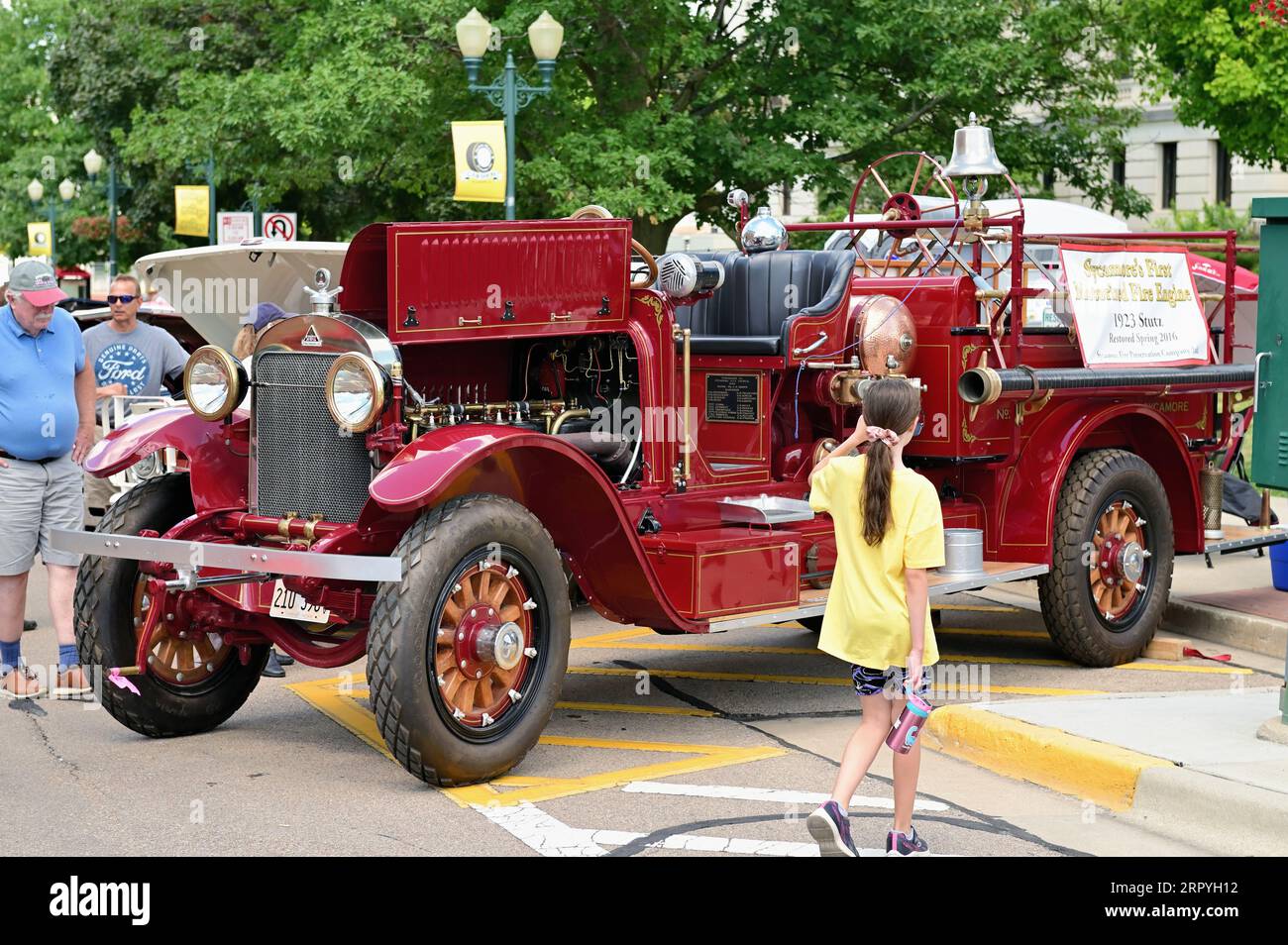 Sycamore, Illinois, USA. Eine jährliche Oldtimer-Show, die die Hauptstraßen der kleinen Gemeinde im Nordosten von Illinois dominiert. Ein junges Mädchen, das gelesen wird Stockfoto