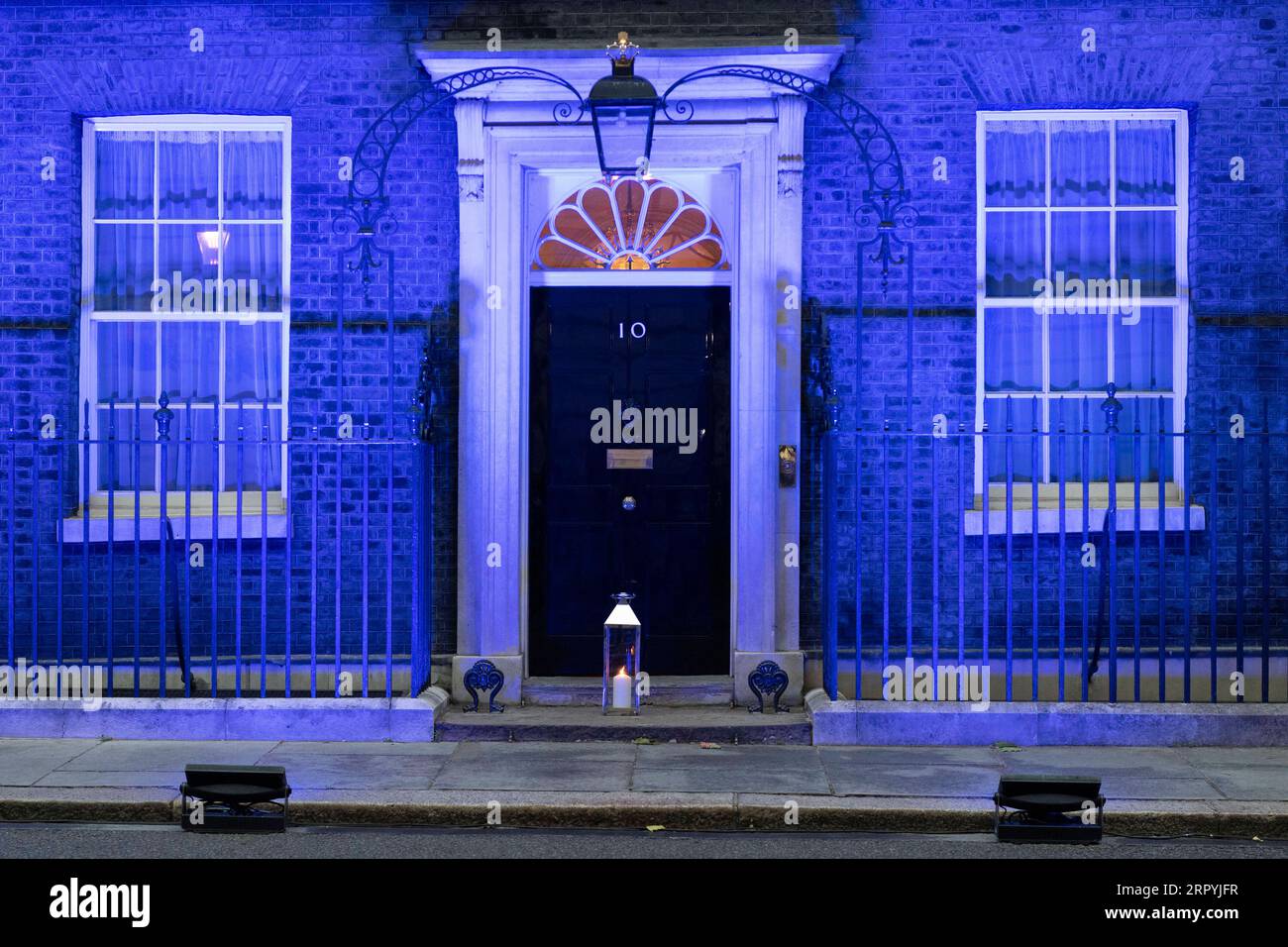 200705 -- LONDON, 5. Juli 2020 Xinhua -- Eine Kerze wird an der Vorderseite der Downing Street platziert, während das Gebäude blau beleuchtet wird, um den 72. Jahrestag des National Health Service NHS in London, Großbritannien am 4. Juli 2020 zu feiern. Laut lokalen Medien wurden Dutzende von Wahrzeichen im ganzen Land blau beleuchtet, um 72 Jahre seit der Gründung des NHS zu markieren. Foto von Ray Tang/Xinhua BRITAIN-LONDON-LANDMARKS-LIT BLUE-NHS-72ND ANNIVERSARY PUBLICATIONxNOTxINxCHN Stockfoto