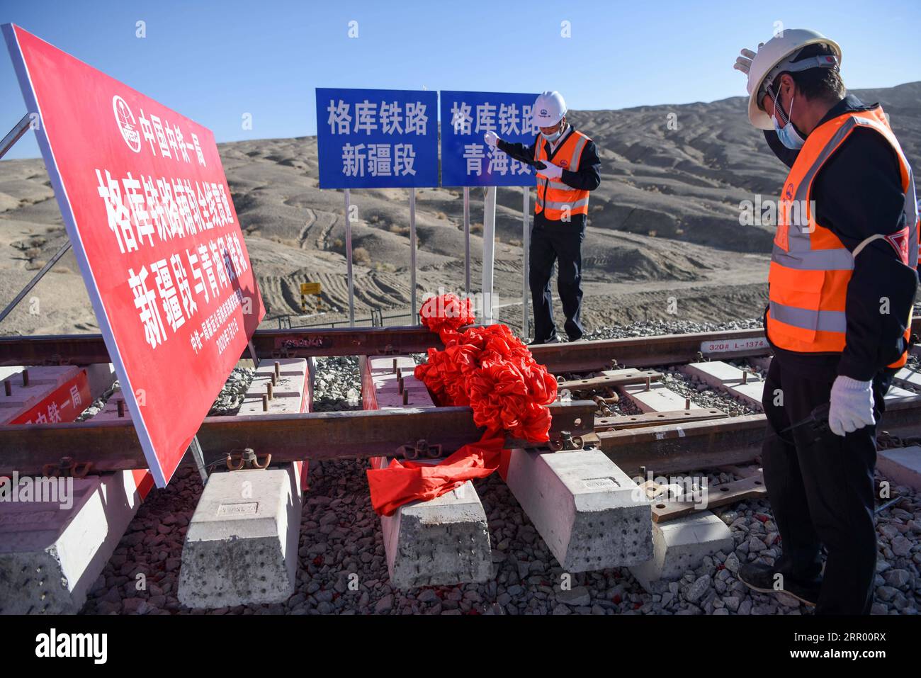 200721 -- RUOQIANG, 21. Juli 2020 -- Arbeiter legen die letzten Gleise auf der Golmud-Korla-Eisenbahnstrecke nahe dem Altun-Gebirge in der nordwestchinesischen autonomen Region Xinjiang Uygur, 21. Juli 2020. Die Verlegung von Gleisen für eine neue Strecke, die die autonome Region Xinjiang Uygur im Nordwesten Chinas mit der Provinz Qinghai und darüber hinaus verbindet, wurde am Dienstag abgeschlossen und ebnete den Weg für eine beschleunigte Entwicklung in der westlichen Region des Landes. Die 1.213,7 km lange Golmud-Korla-Bahn verbindet die Stadt Golmud in Qinghai mit der Stadt Korla in Xinjiang und soll noch in diesem Jahr in Betrieb genommen werden. CHINA-XINJI Stockfoto