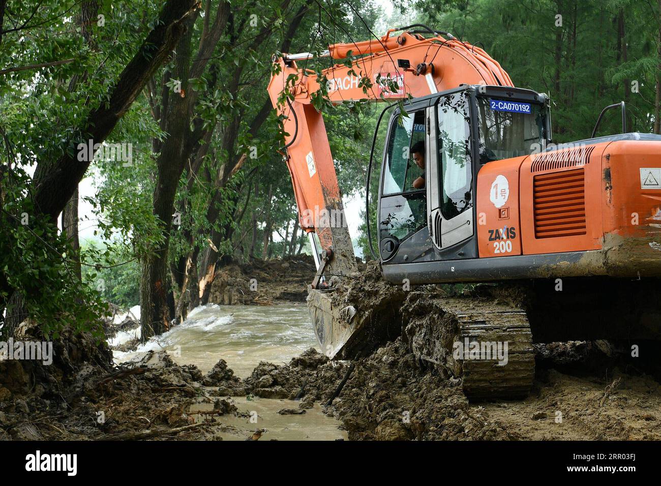 200726 -- HEFEI, 26. Juli 2020 -- Ein Arbeiter betreibt einen Bagger, um einen Kanal zwischen einem Hochwasserlager und dem Jiangkou-Fluss in Feixi County von Hefei, ostchinesische Provinz Anhui, zu graben, 26. Juli 2020. Ein Hochwasserlager in der Nähe des Jiangkou River im Feixi County wurde am Sonntag in Betrieb genommen, da der Wasserstand im nahegelegenen Chaohu Lake hoch blieb. Die Bewohner, die aufgrund der Hochwasserlagerung betroffen waren, waren bereits evakuiert worden. CHINA-ANHUI-FEIXI-FLOOD DIVERSION CN LIXXIN PUBLICATIONXNOTXINXCHN Stockfoto