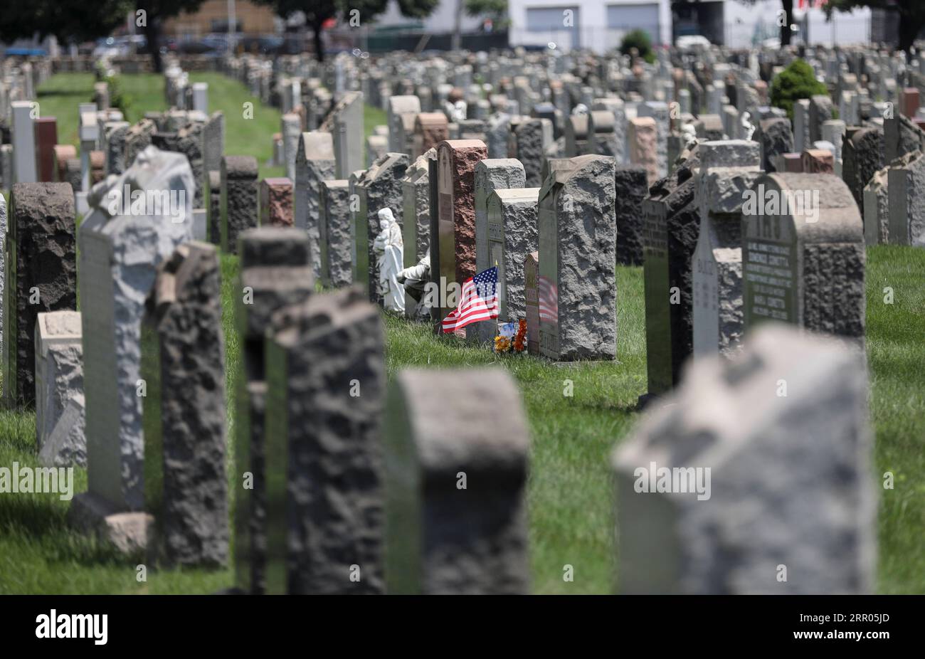 200730 -- NEW YORK, 30. Juli 2020 -- Eine US-Nationalflagge und Blumen sind auf einem Friedhof in New York, den Vereinigten Staaten, am 29. Juli 2020 zu sehen. COVID-19-Todesfälle in den USA haben die 150.000-Marke überschritten und erreichen am Mittwoch, 1935 GMT, um 15:35 Uhr Ortszeit 150.034, so das Center for Systems Science and Engineering an der Johns Hopkins University. U.S.-NEW YORK-COVID-19-CASES WangxYing PUBLICATIONxNOTxINxCHN Stockfoto