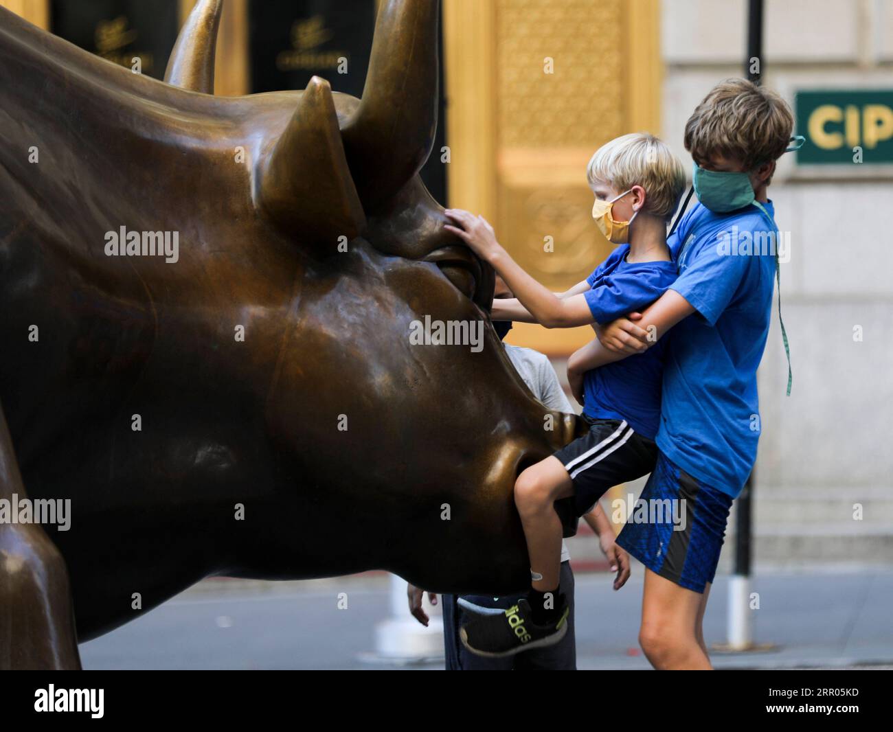 200730 -- NEW YORK, 30. Juli 2020 -- Kinder spielen auf dem Charging Bull in New York, USA, 29. Juli 2020. COVID-19-Todesfälle in den USA haben die 150.000-Marke überschritten und erreichen am Mittwoch, 1935 GMT, um 15:35 Uhr Ortszeit 150.034, so das Center for Systems Science and Engineering an der Johns Hopkins University. U.S.-NEW YORK-COVID-19-CASES WangxYing PUBLICATIONxNOTxINxCHN Stockfoto