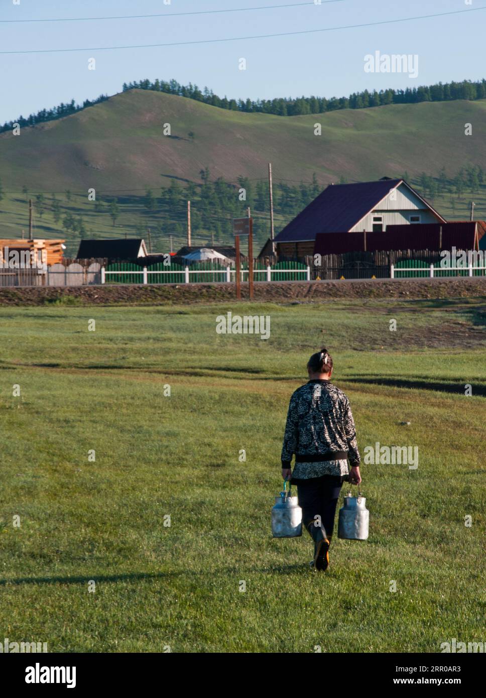 Ein Dorf Frau geht nach Hause, die Wasser vom See Khovsgol, nördliche Mongolei Stockfoto