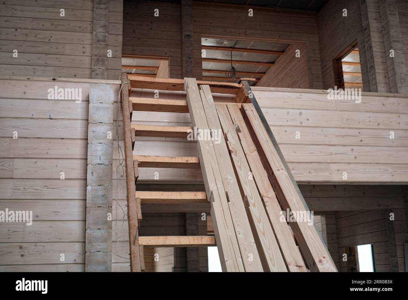 Eine provisorische Holztreppe, die in ein unvollendetes Haus führt Stockfoto