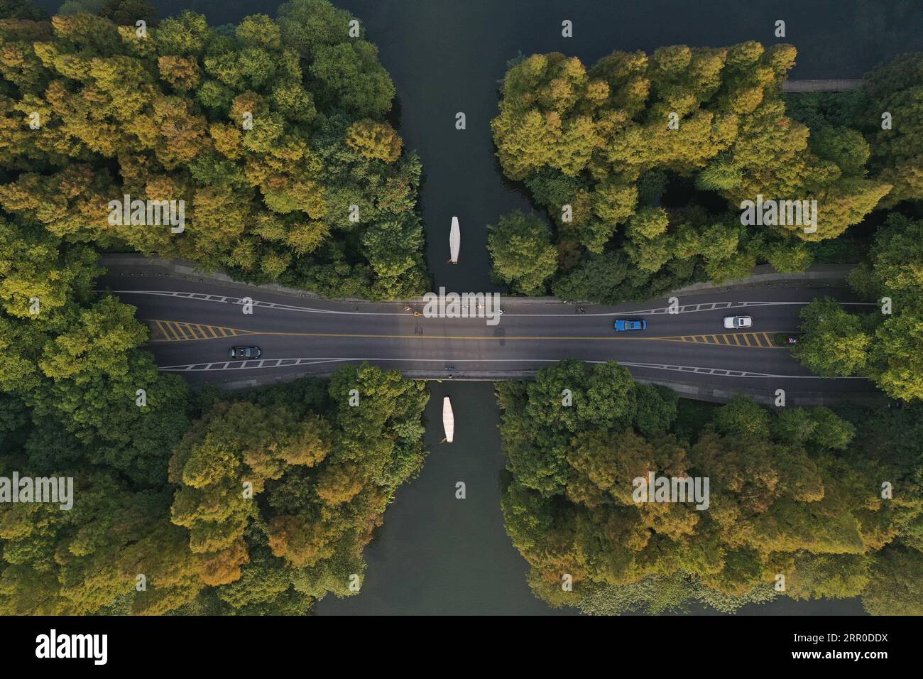 200810 -- HANGZHOU, 10. Aug. 2020 -- Luftaufnahme aufgenommen am 29. Oktober 2019 zeigt Autos, die auf dem Yanggongdi-Damm am West Lake in Hangzhou, der ostchinesischen Provinz Zhejiang, fahren. Die Kulturlandschaft des West Lake in Hangzhou, umrahmt von wolkenbedeckten Hügeln auf drei Seiten und aufgeteilt in mehrere Teile durch malerische Dämme, präsentiert eine zarte Landschaft mit sich überlappenden Gipfeln und verstreuten Tempeln, Pagoden, Pavillons, Gärten, Zierbäumen, und künstliche Inseln, die der Stadt Hangzhou Schönheit verleihen. Es wurde vom Weltkulturerbe-Komitee für das UNESCO-Weltnaturerbe eingeschrieben Stockfoto