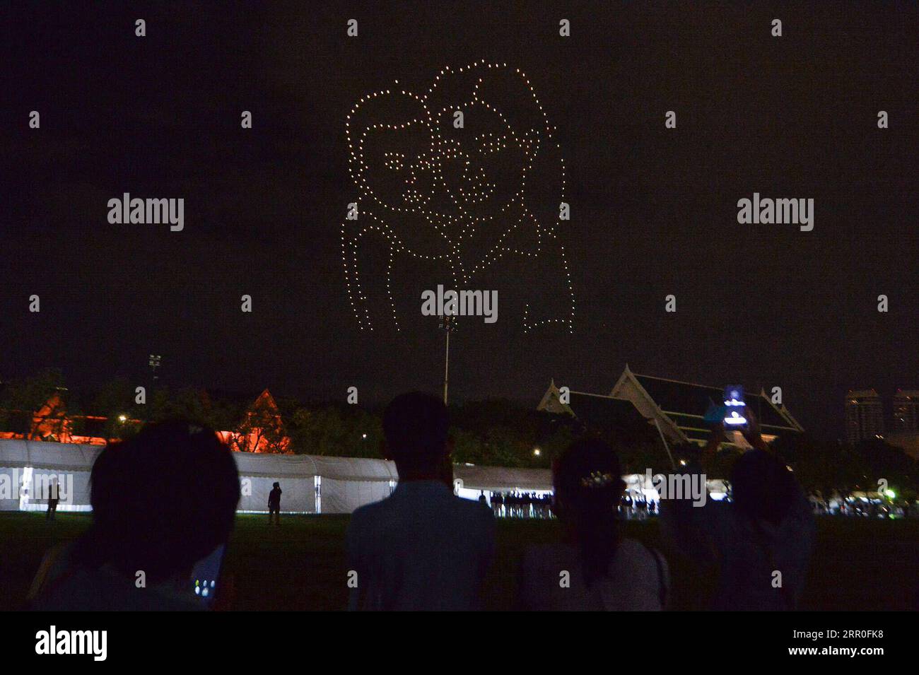 200813 -- BANGKOK, 13. August 2020 -- Menschen beobachten eine Drohnenvorstellung während einer Veranstaltung zum 88. Geburtstag der thailändischen Königin Mutter Sirikit in der Nähe des Großen Palastes in Bangkok, Thailand, 12. August 2020. THAILAND-BANGKOK-KÖNIGIN MUTTERGEBURTRACHENXSAGEAMSAK PUBLICATIONxNOTxINxCHN Stockfoto