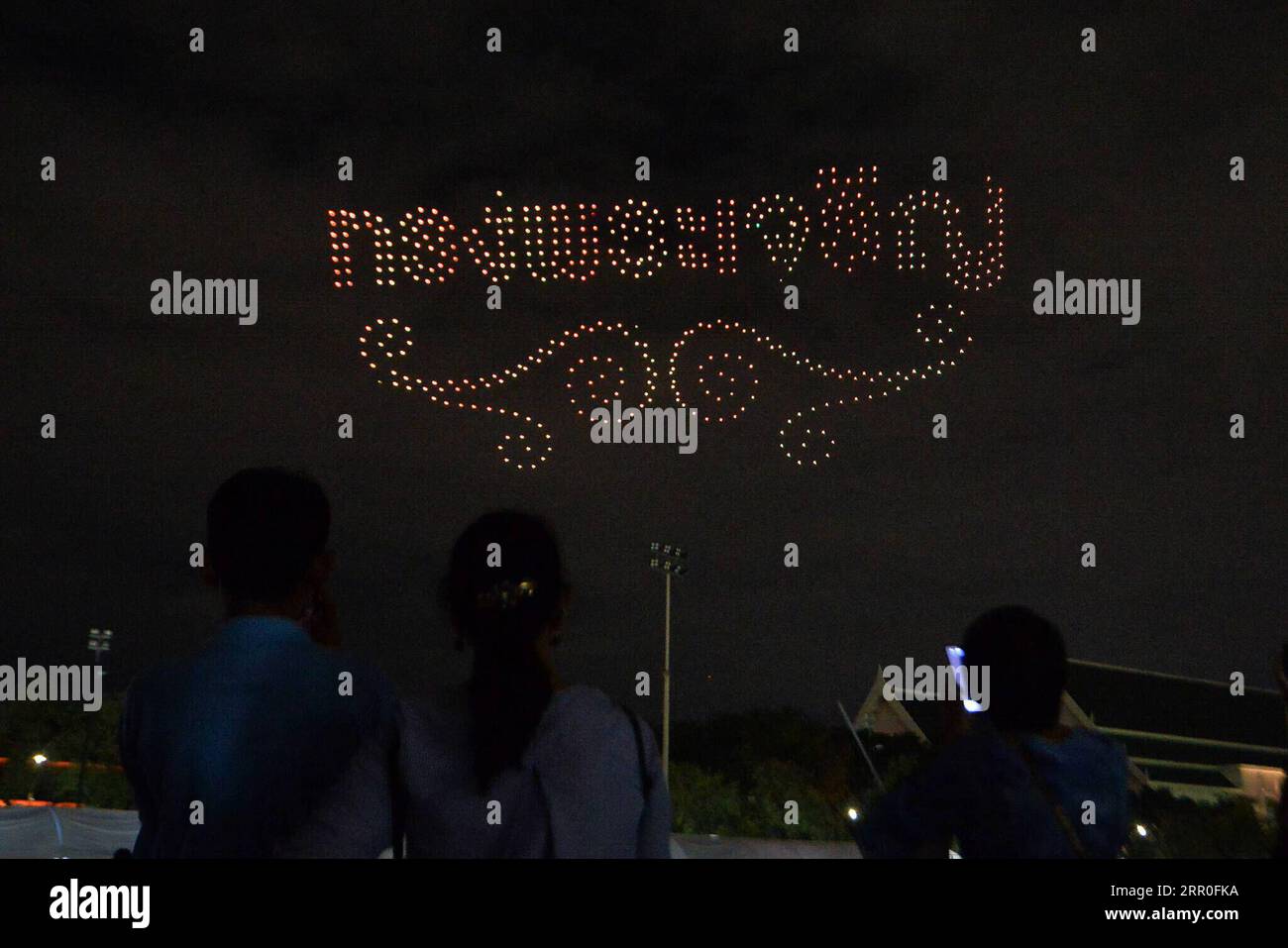 200813 -- BANGKOK, 13. August 2020 -- Menschen beobachten eine Drohnenvorstellung während einer Veranstaltung zum 88. Geburtstag der thailändischen Königin Mutter Sirikit in der Nähe des Großen Palastes in Bangkok, Thailand, 12. August 2020. THAILAND-BANGKOK-KÖNIGIN MUTTERGEBURTRACHENXSAGEAMSAK PUBLICATIONxNOTxINxCHN Stockfoto
