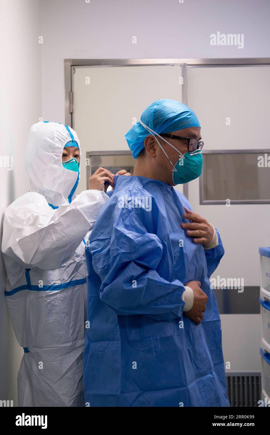 200818 -- PEKING, 18. Aug. 2020 -- Tong Zhaohui zieht am 13. Aug. 2020 Schutzkleidung im Beijing Ditan Hospital in Peking, der Hauptstadt Chinas, an. Tong ist Vizepräsident des Pekinger Chao-Yang Krankenhauses und Experte der medizinischen Behandlungsgruppe der Nationalen Gesundheitskommission. Er gehörte zu den ersten Experten für Atemwegserkrankungen und kritische Erkrankungen, die in Wuhan ankamen, um lokale Ärzte bei ihrem Kampf gegen COVID-19 zu unterstützen. Nach drei Monaten kontinuierlicher Arbeit in Wuhan reiste er nach Heilongjiang, Jilin, Qingdao und Peking, um die Seuchenbehandlung zu leiten, und rettete eine große Anzahl von Kritikpunkten Stockfoto