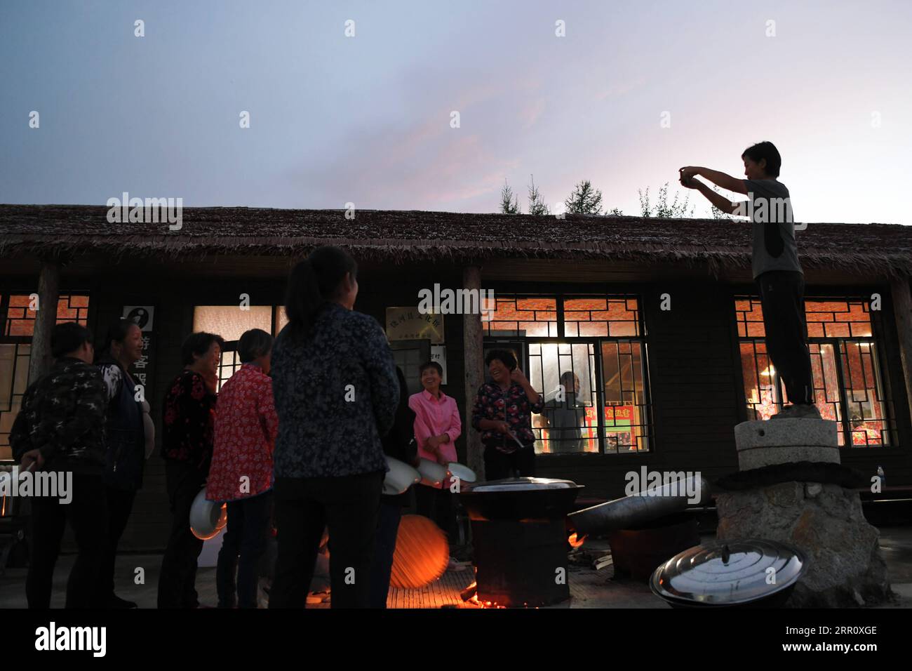 200828 -- HARBIN, 28. August 2020 -- Leng Juzhen R macht Fotos von Dorfbewohnern vor dem Tourismuszentrum in Xiaonanhe Village im Raohe County, nordöstliche chinesische Provinz Heilongjiang, 19. August 2020. Dieses Jahr ist Leng Juzhens fünftes Jahr als Beamter, der Xiaonanhe zur Unterstützung der Armutsbekämpfung zugeteilt wurde. Durch die Bemühungen von Leng und anderen Dorfbediensteten schürten alle von Armut betroffenen Haushalte in Xiaonanhe 2018 die Armut. In den letzten Jahren hat Leng die Dorfbewohner geführt, um den ländlichen Tourismus und landwirtschaftliche Produkte wie Chilisauce, Käfiglose Hühner und zu entwickeln Stockfoto