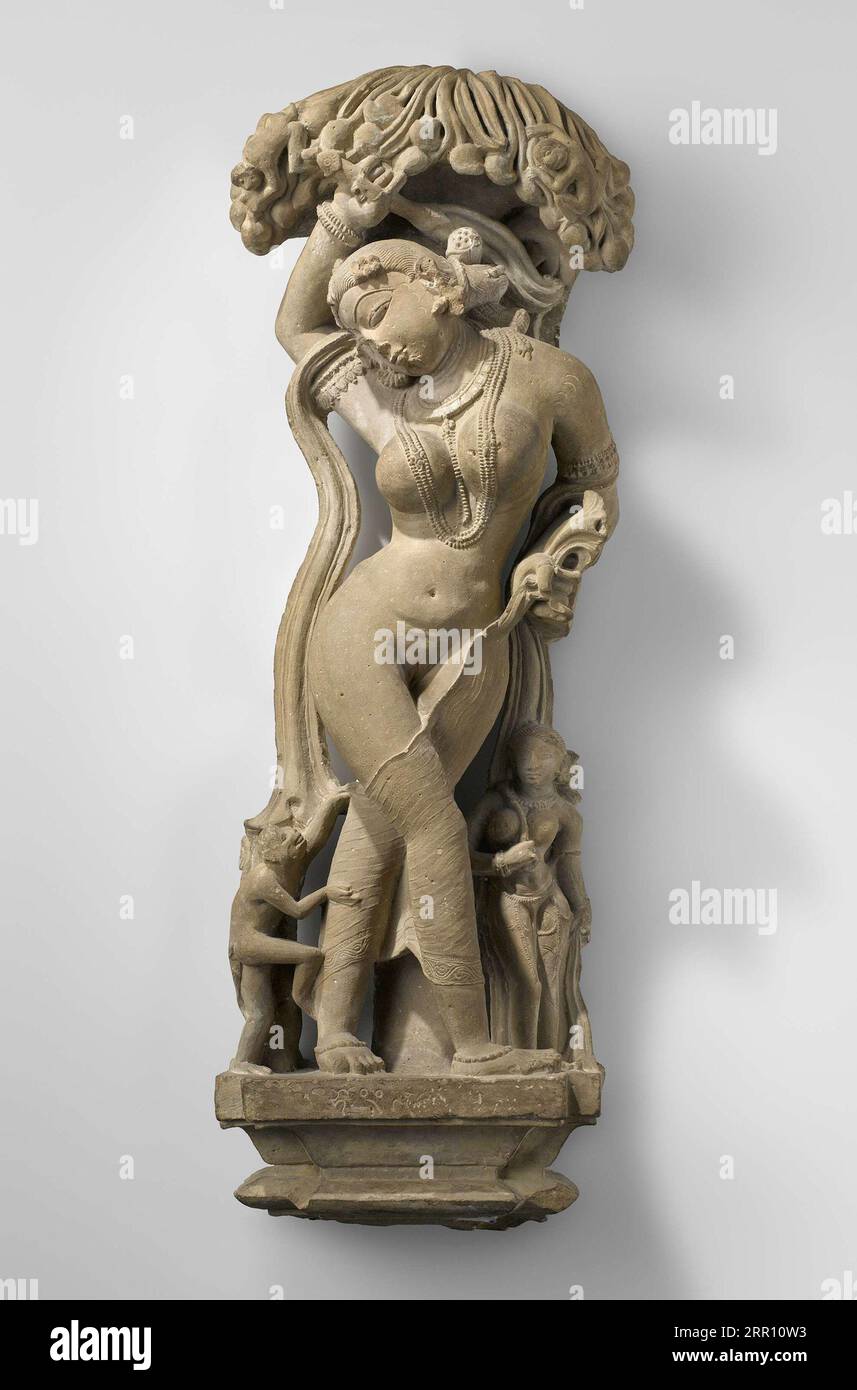 Indische Kunst, Kunsthandwerk, weibliche Figur hat ihren Fliegenbesen hochgehoben, um den kleinen Affen wegzubürsten, der an ihrem anhängenden Unterkleid zerrt. Die Fingerabdrücke des Fingers Stockfoto