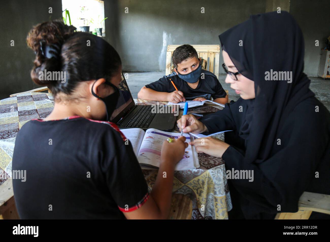 200902 -- GAZA, 2. September 2020 -- Eine palästinensische Frau unterrichtet ihre Kinder in ihrem Haus in der Stadt Beit Lahia im nördlichen Gazastreifen am 1. September 2020. ZUM Mitmachen: Gaza-Schüler wenden sich nach Schulschluss unter COVID-19-Wiederbelebung alternativen Bildungsmethoden zu Foto von /Xinhua MIDEAST-GAZA-BILDUNG RizekxAbdeljawad PUBLICATIONxNOTxINxCHN Stockfoto